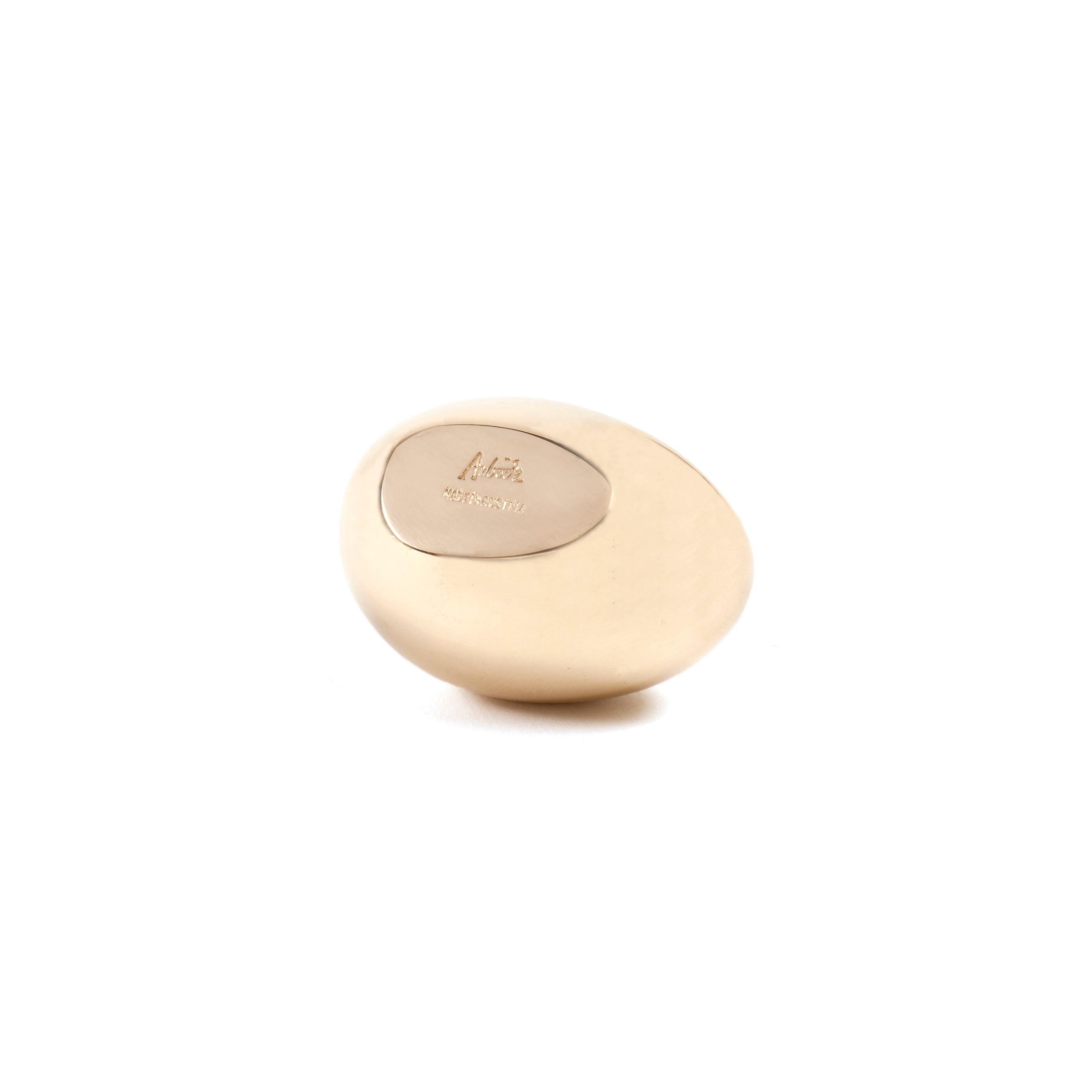 The Paperweight Egg #4867 by Werkstätte Carl Auböck features a smooth, beige stone with an oval silver plate engraved in delicate script. Its polished surface and rounded edges reflect refined sensibility, resting elegantly on a plain white background.