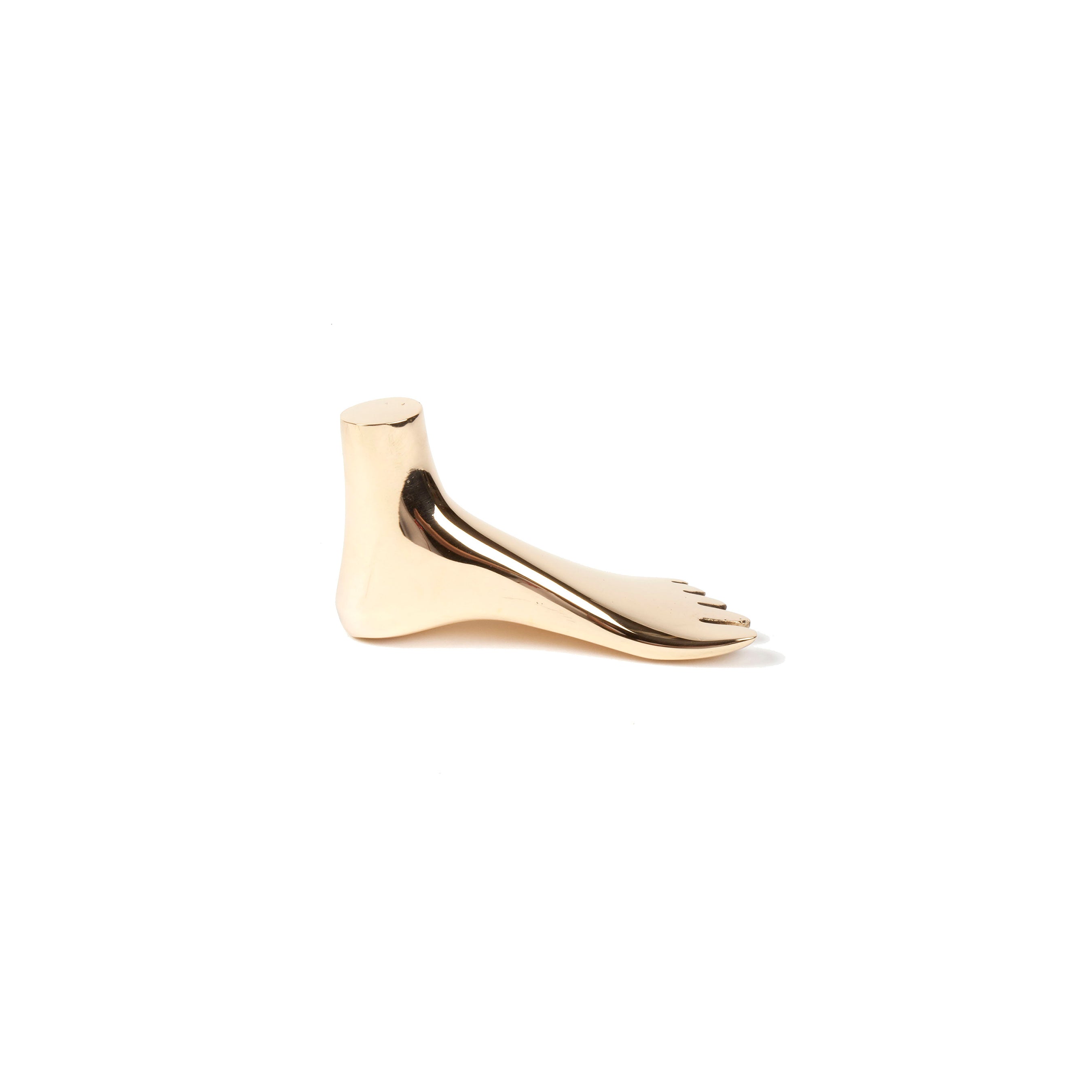 The Paperweight Foot #4273 by Werkstätte Carl Auböck is a sleek, polished brass sculpture styled as a right foot with five toes, set against a plain white background.