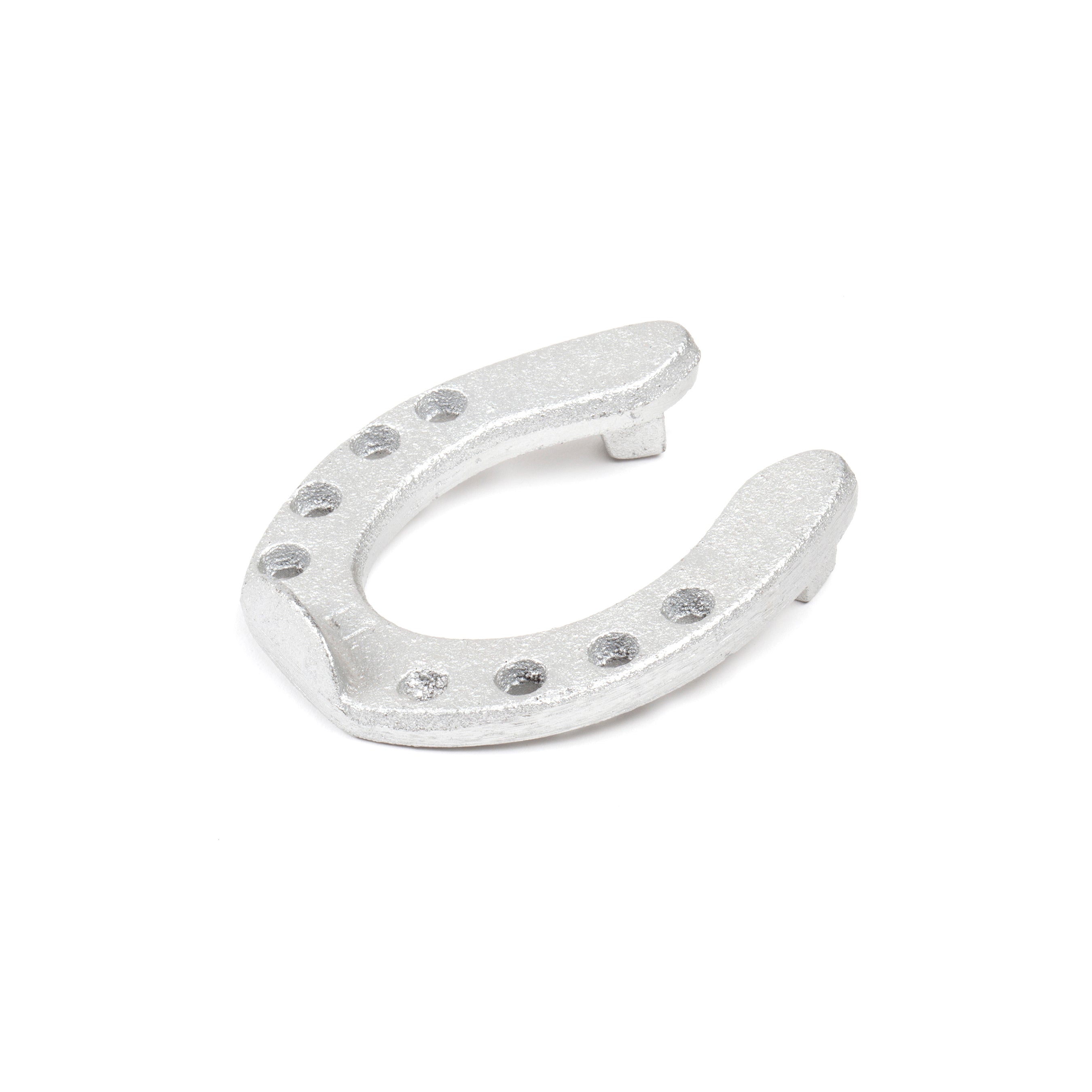 The Pencil Holder Horse Shoe #5138 from Werkstätte Carl Auböck is a silver piece with eight small holes, lying flat on a white background, embodying the timeless elegance and innovation of Carl Auböcks craftsmanship.