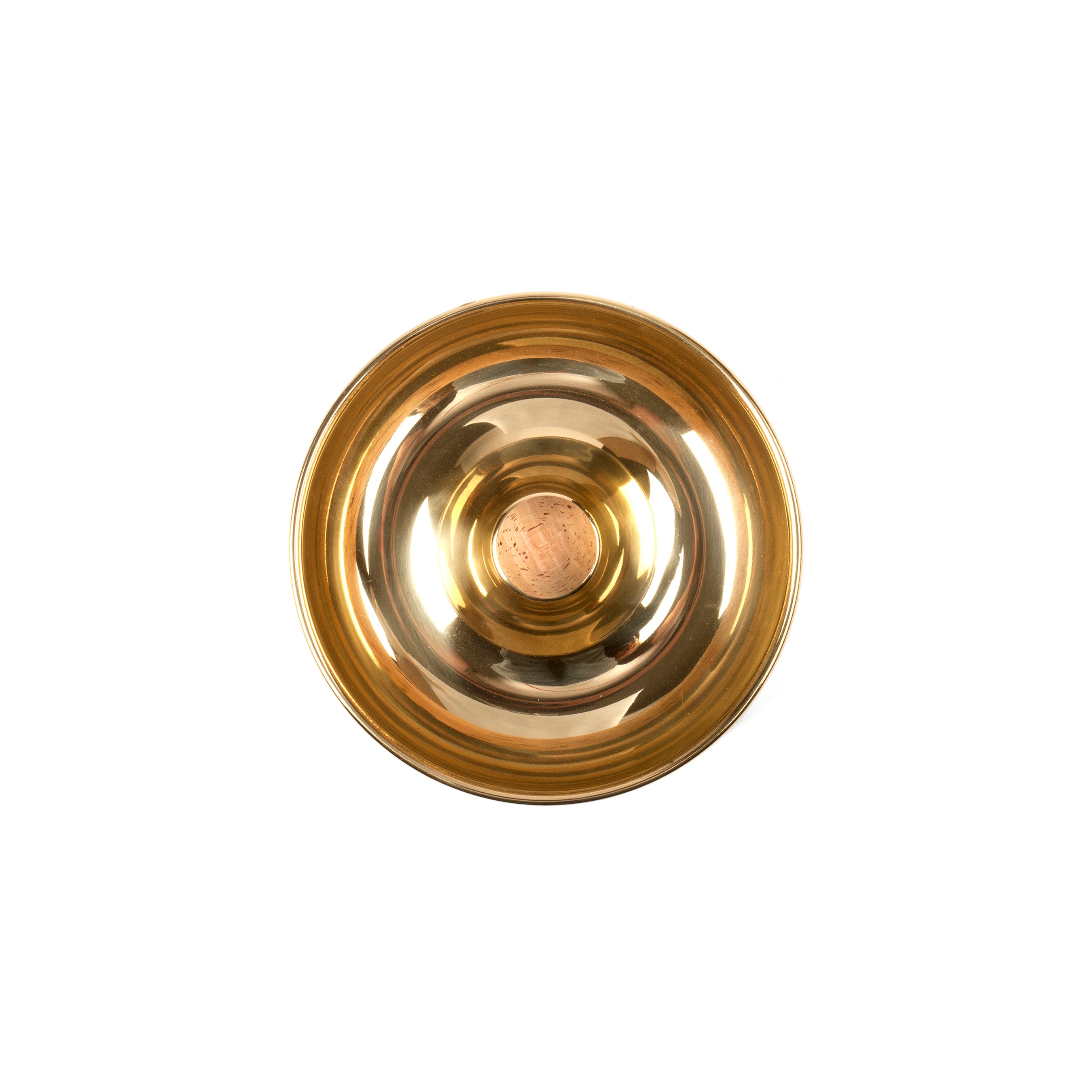 A Werkstätte Carl Auböck Pipe Ashtray #7202, featuring circular concentric grooves, is viewed from above on a white background. Its polished brass surface shines brighter at the center, creating a gradient effect towards the edges.