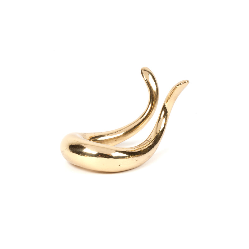 The Pipe Stand #3294 by Werkstätte Carl Auböck is a sleek, gold abstract sculpture featuring two upward-curving horn-like protrusions on a flat base, perfect for enhancing the interior of a classic Viennese townhouse against a white background.