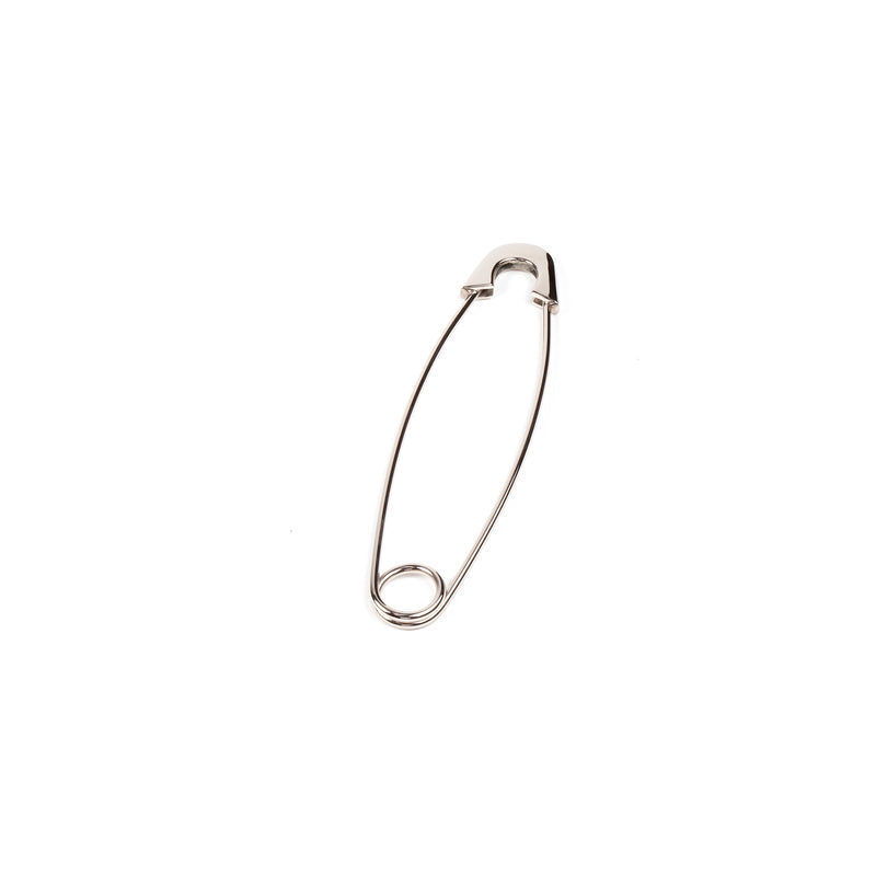 The Paperweight Safety Pin #4992 by Werkstätte Carl Auböck, a closed silver pin exuding Viennese minimalist elegance, stands vertically against a plain white backdrop.