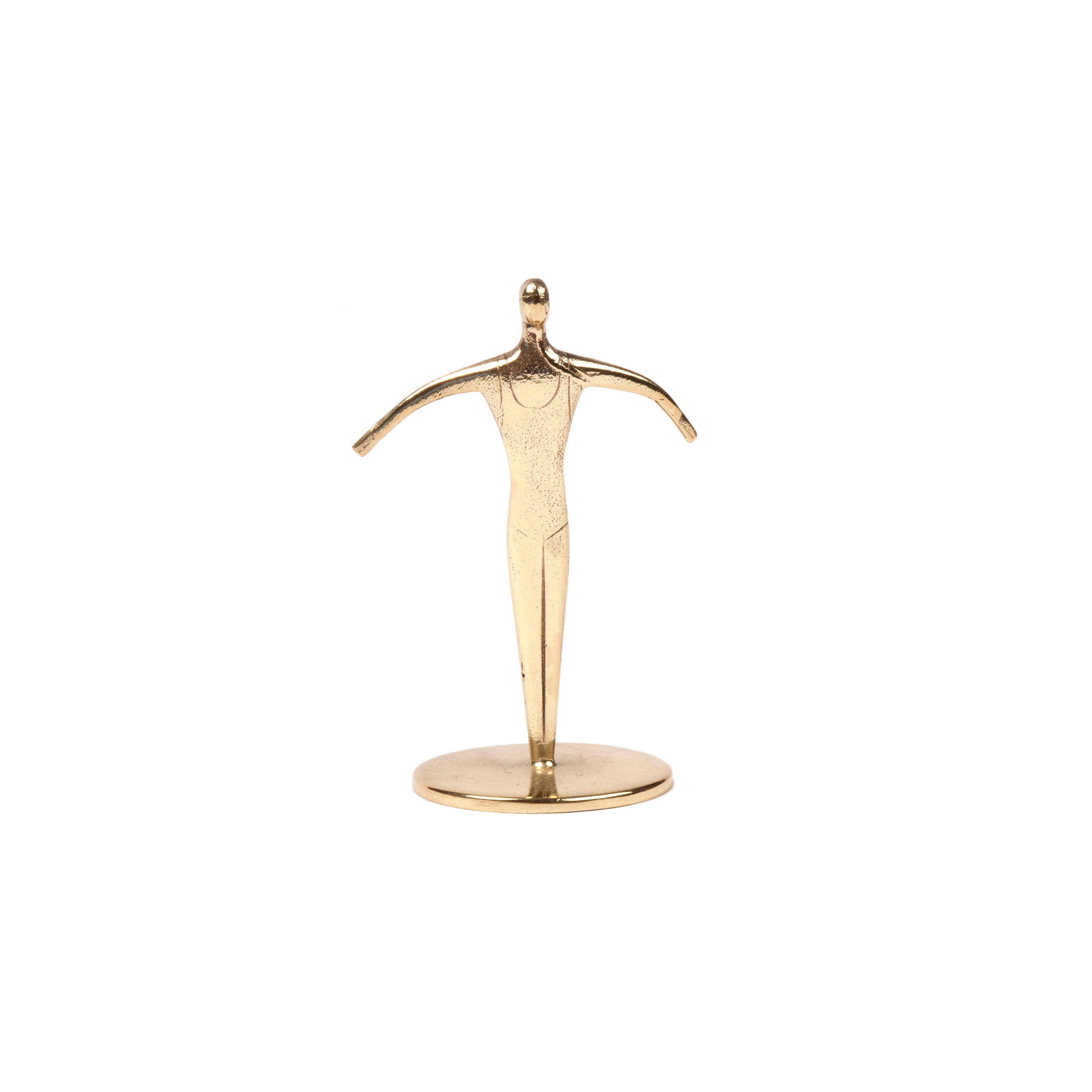 The Werkstätte Carl Auböck creation, Sculpture Sportsman #7204, is a small golden piece depicting a stylized human figure with outstretched arms on a round base. Its minimal facial features reflect the charm of Wiener Bronzen against a plain white background.