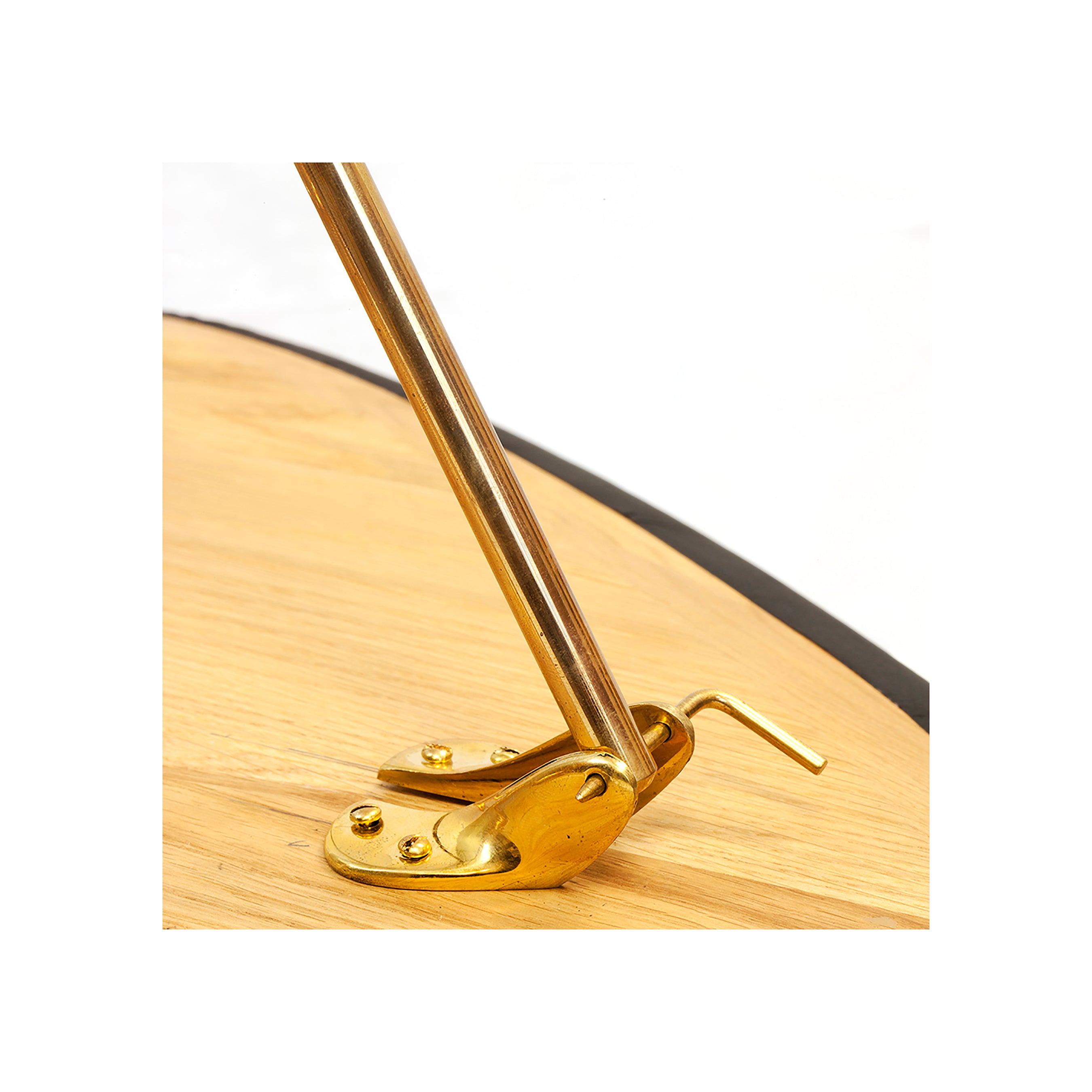 A close-up of the Sidetable #3642 by Werkstätte Carl Auböck highlights its polished brass hinge and support rod contrasted against light wood. The securely screwed hinge complements the elegantly extending rod.