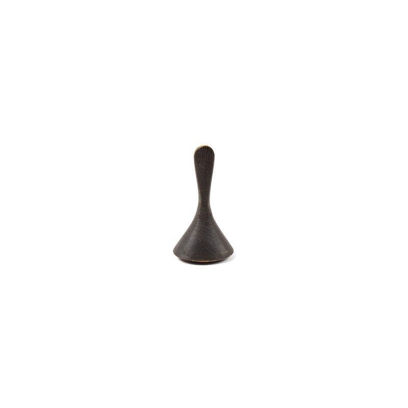 A small, metallic cone-shaped object with a narrow, rounded handle on top resembling a spinning top by Werkstätte Carl Auböck is centered on a plain white background. It is the Snuffer #4117A.