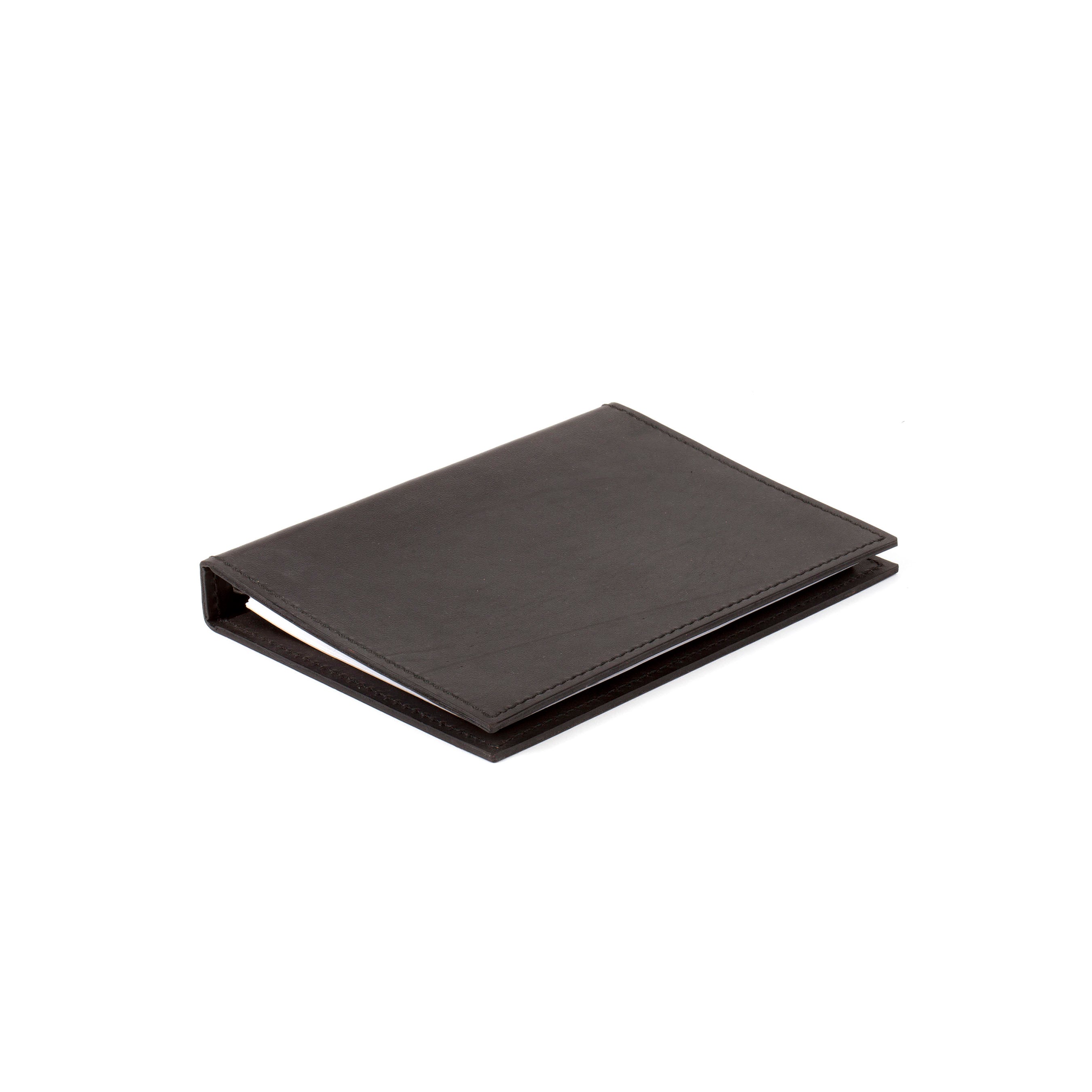 A sleek, closed black leather Telephone Register #5116/1 by Werkstätte Carl Auböck is set against a white backdrop. Its minimalist design echoes the elegance of a Viennese townhouse, with no visible branding to detract from its simple beauty.