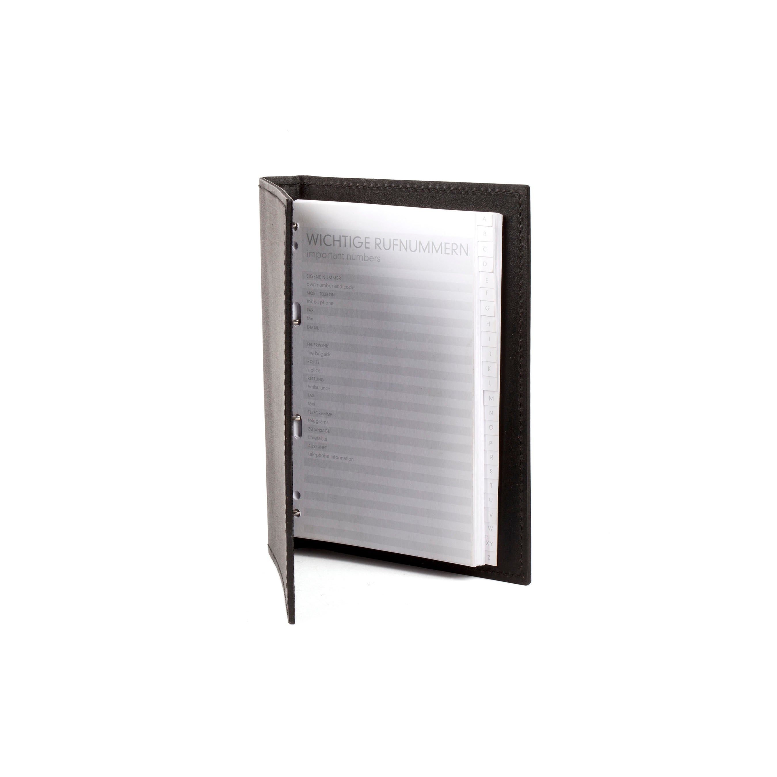 The Telephone Register #5116/1 by Werkstätte Carl Auböck, a dark leather-bound address book, opens to Wichtige Rufnummern (Important Numbers). Its sleek design with visible stitching echoes the artistry of a Viennese townhouse set against a plain white background.