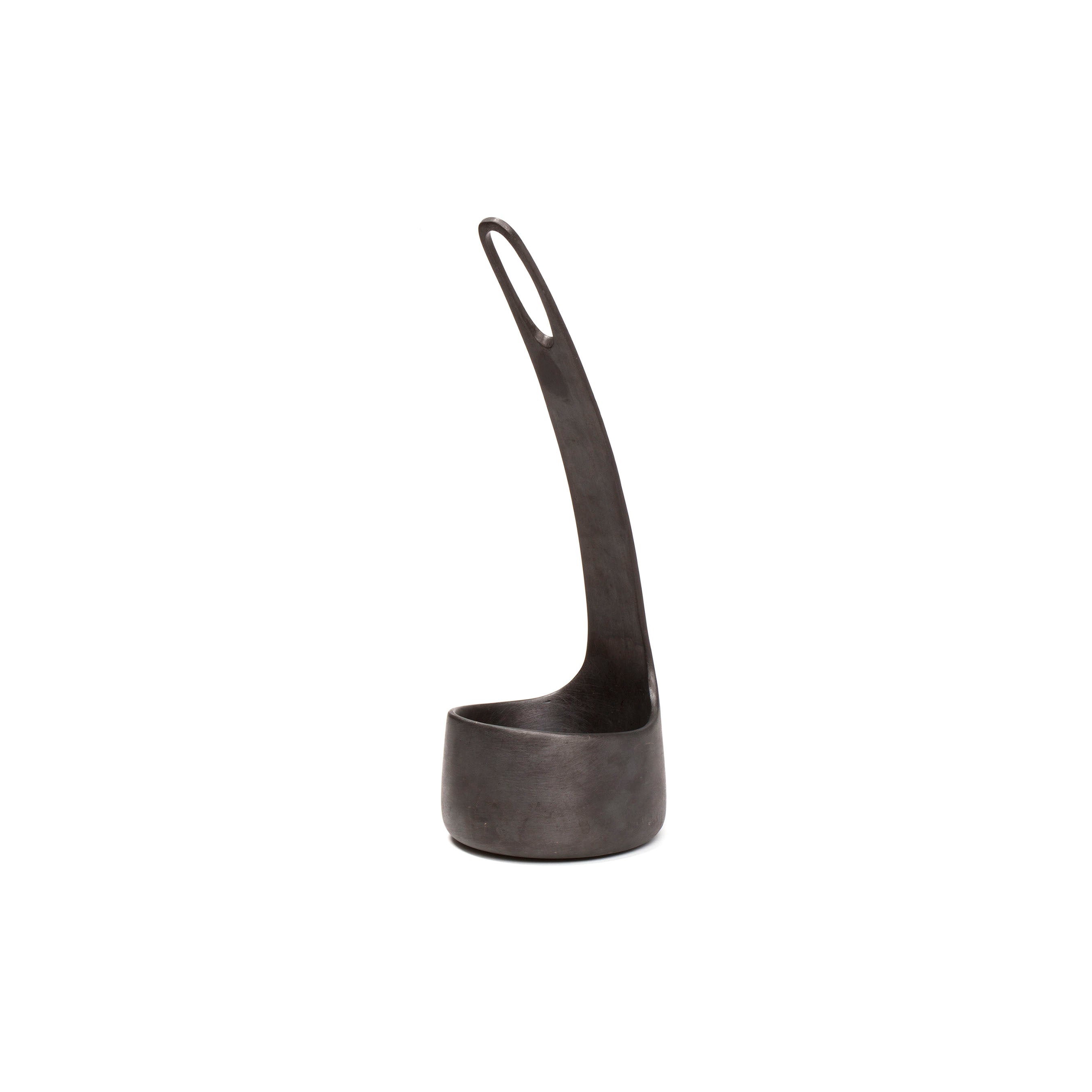 The Vase Single Flower #4276 by Werkstätte Carl Auböck is a modern, black metal piece with a sleek, elongated handle and narrow base. Its loop handle design adds functionality and minimalist elegance reminiscent of a Viennese townhouse.