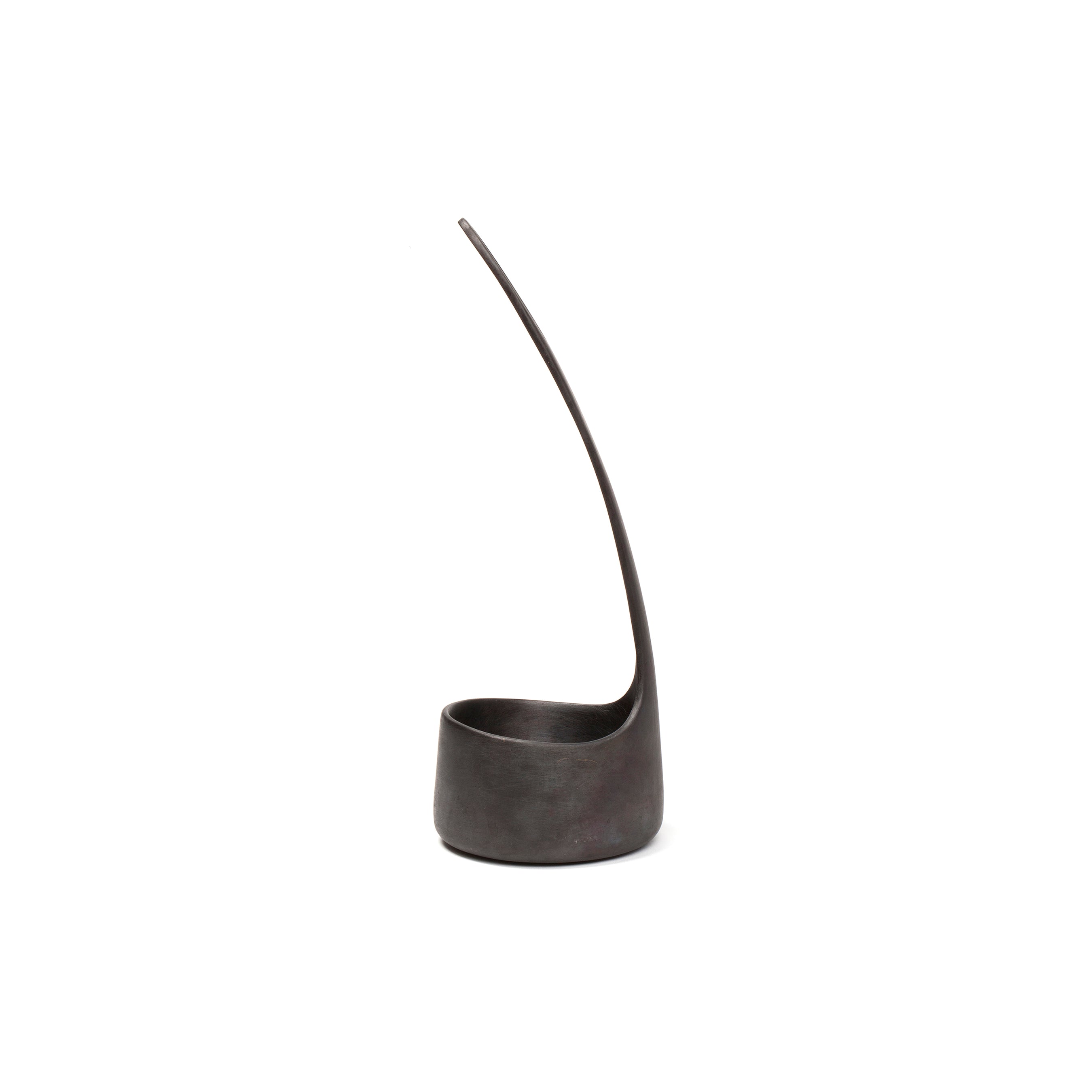 The Vase Single Flower #4276 by Werkstätte Carl Auböck is a modern, dark metal sculpture with a smooth, rounded base and slender upwards-curving form. Its sleek design evokes the elegance of a Viennese townhouse against a plain white background.