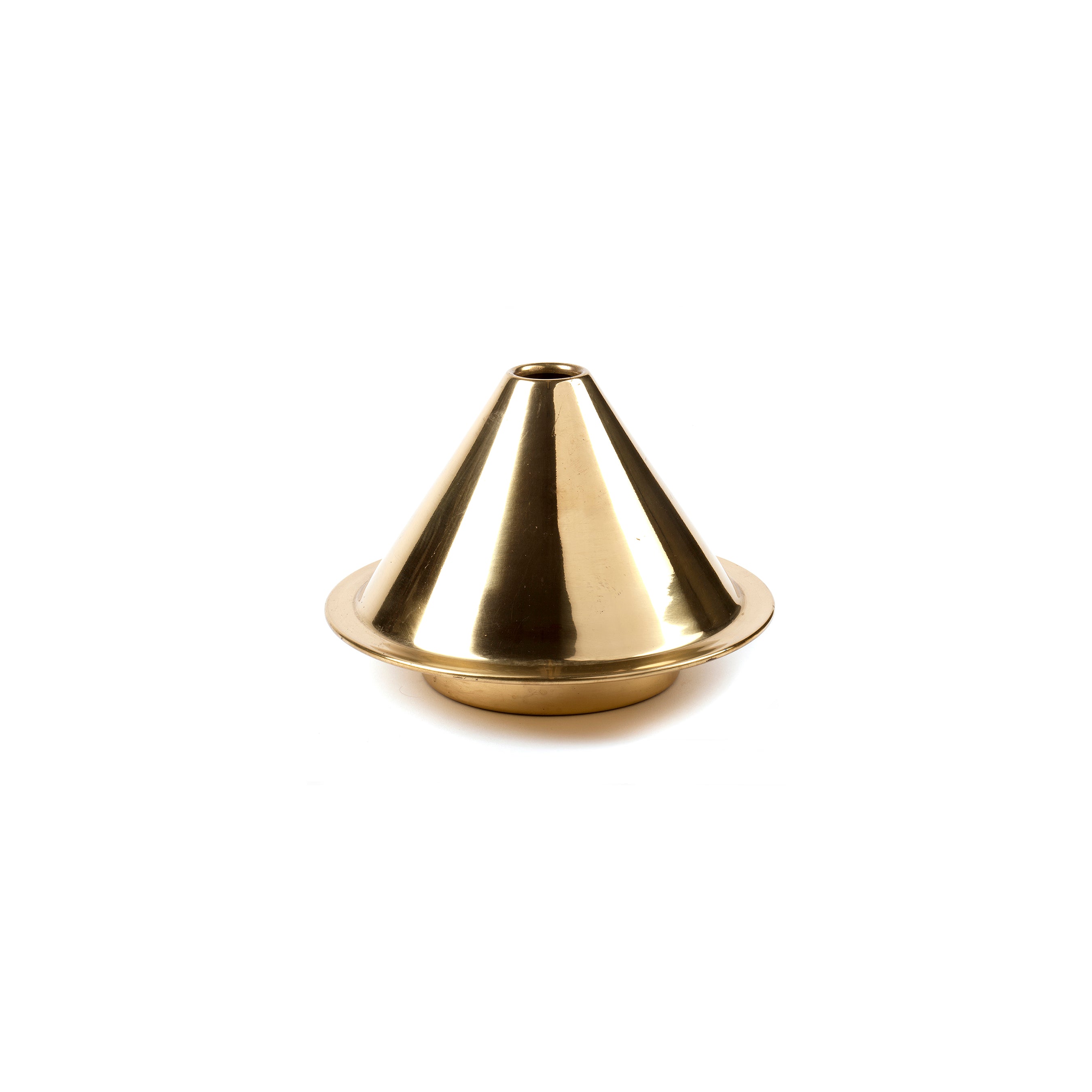 A brass Vase Cone #7144 from Werkstätte Carl Auböck sits on a white surface. Its shiny, conical form features highlights from the overhead lighting, akin to other famed Carl Auböck pieces. The elegant vase has a wide base and tapers to a small top opening.