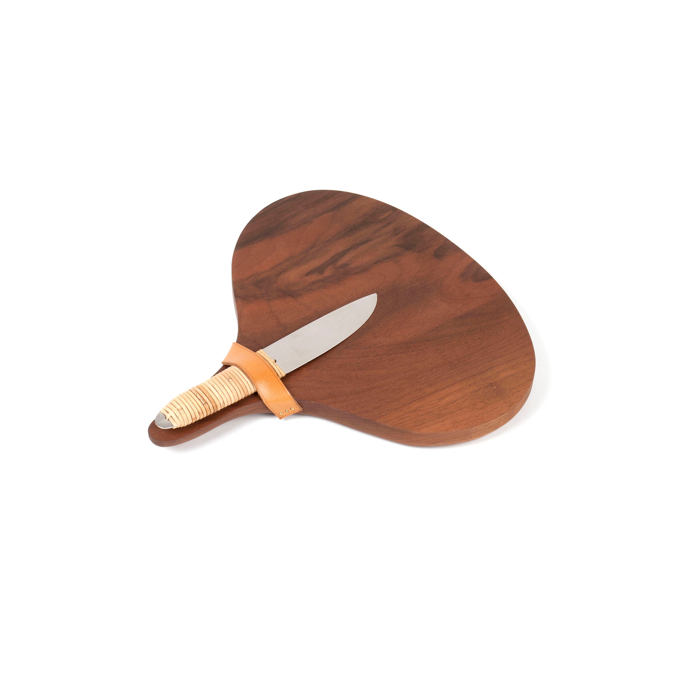 The Walnut Board with Cheeseknife #4363-2 from Werkstätte Carl Auböck features a distinct wooden paddle and silver-bladed knife. Its wrapped handle, secured with a tan leather strap, enhances the dark walnut finish, while the artistic piece rests elegantly on a white background.