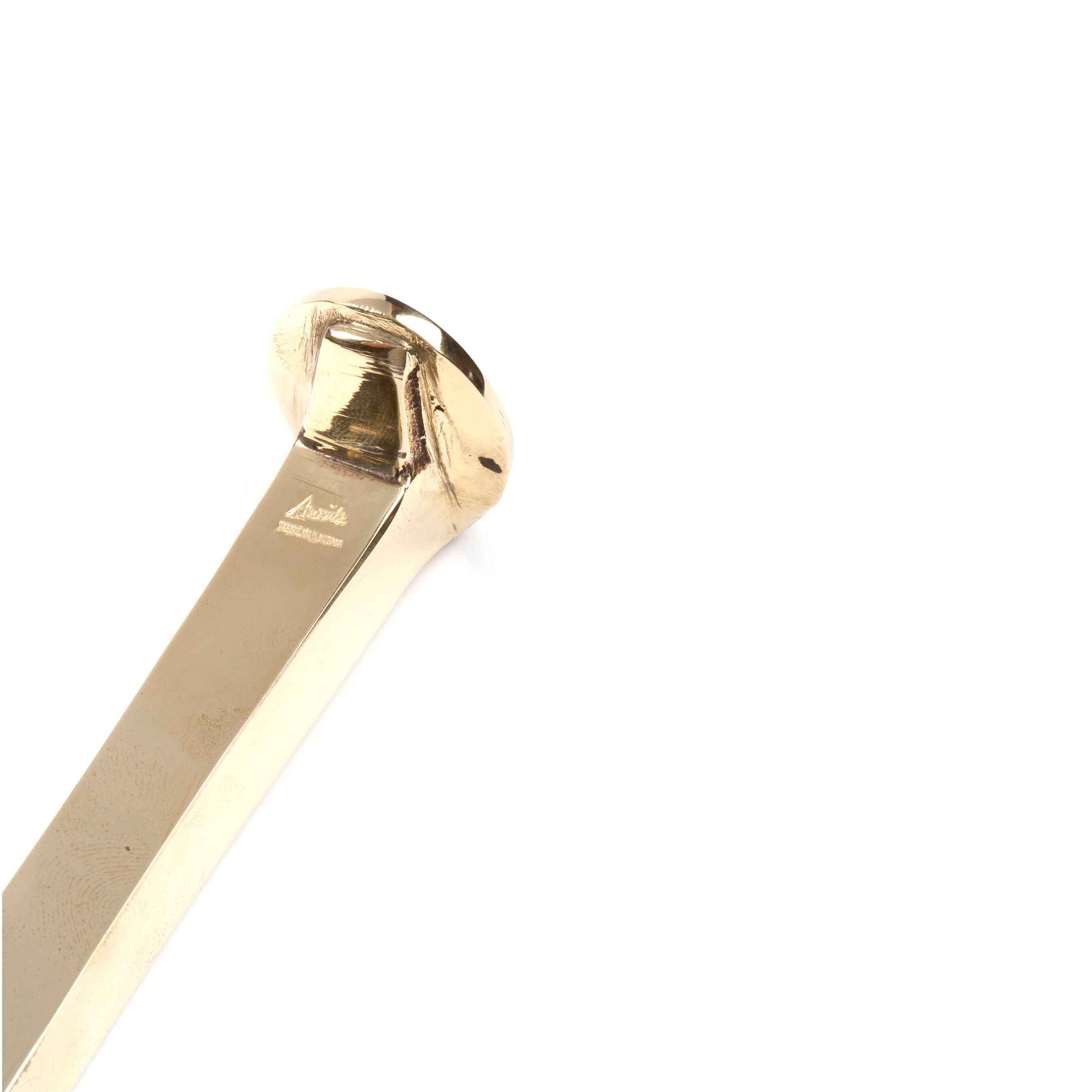 Close-up of a shiny, smooth gold object with a flat surface and wide rounded edges on a plain white background. The exquisite design hints at the functional or decorative Paperweight Railroadnail #5038 by Werkstätte Carl Auböck.