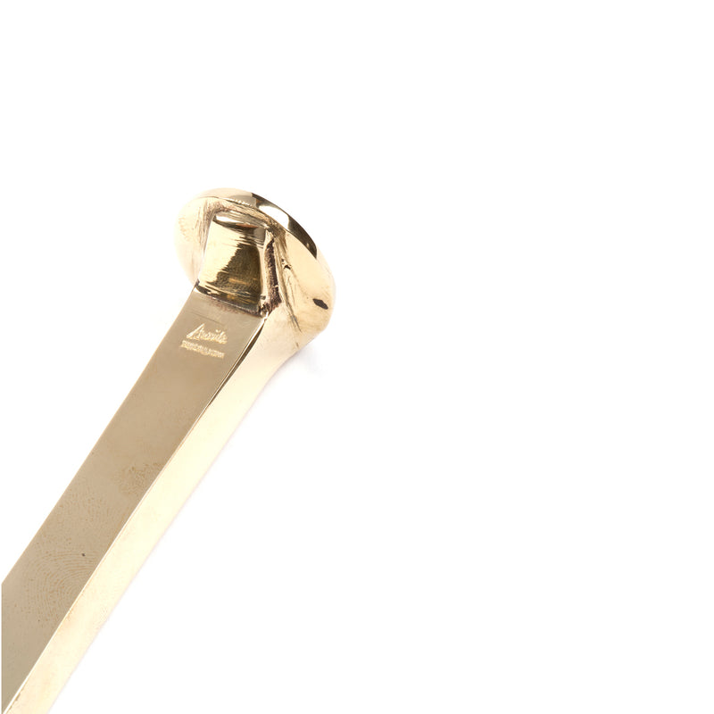 Close-up of a shiny, smooth gold object with a flat surface and wide rounded edges on a plain white background. The exquisite design hints at the functional or decorative Paperweight Railroadnail #5038 by Werkstätte Carl Auböck.