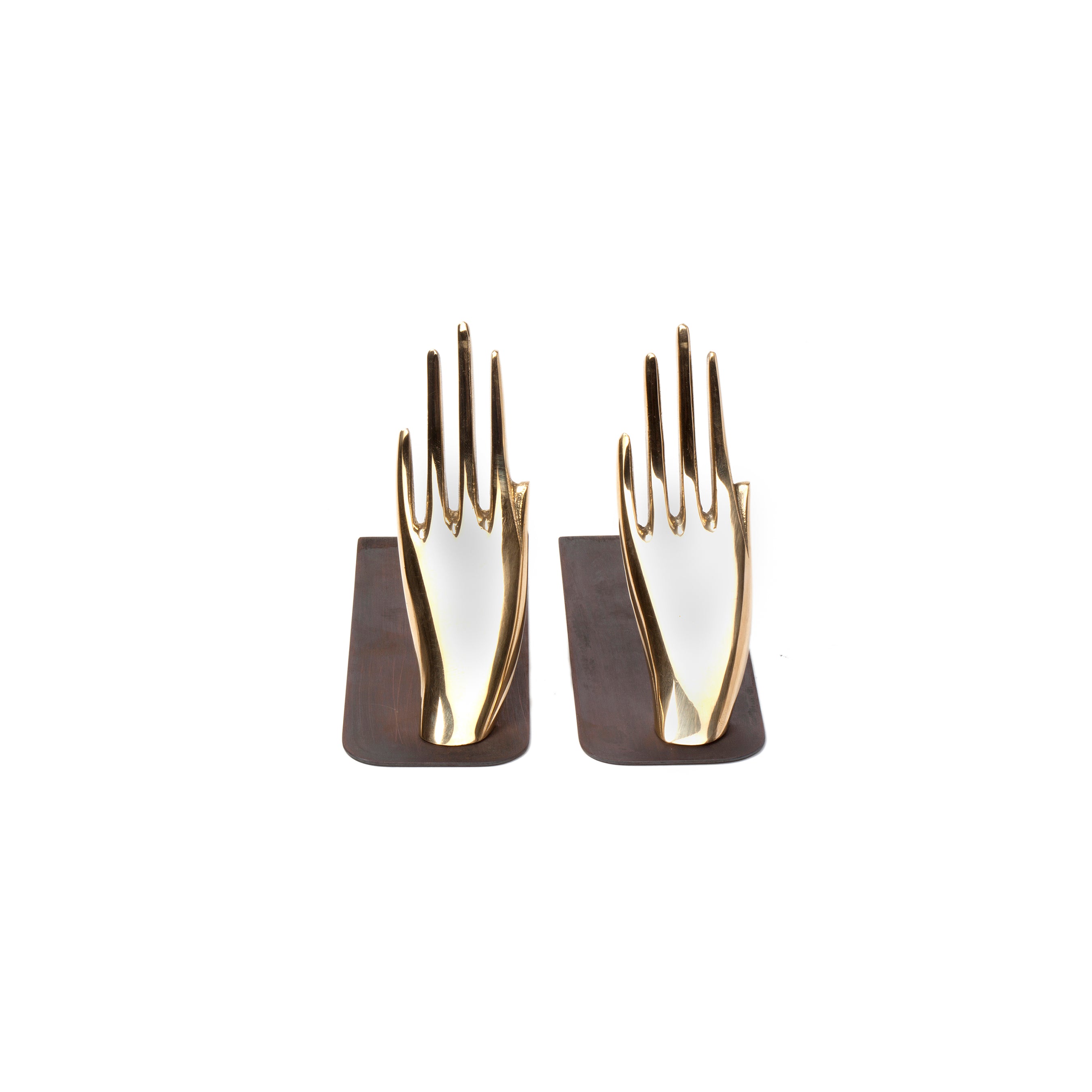 The Pair of Bookends #1928 by Werkstätte Carl Auböck features two gold-colored hand-shaped bookends on dark wooden bases, showcasing elegantly sculpted fingers gently curved upwards against a plain white background, reminiscent of Carl Auböcks refined craftsmanship.
