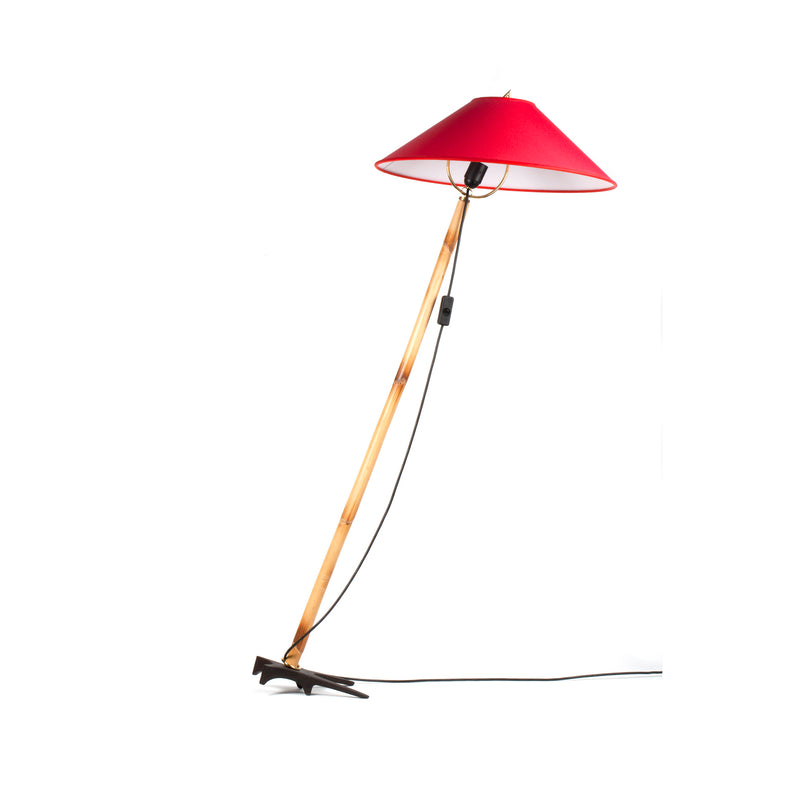 The Floorlamp Butterfly #3740 by Werkstätte Carl Auböck features a slender wooden pole, a bright red conical shade, an origami-like black base, and a switch-equipped cord. It leans slightly against a white background.