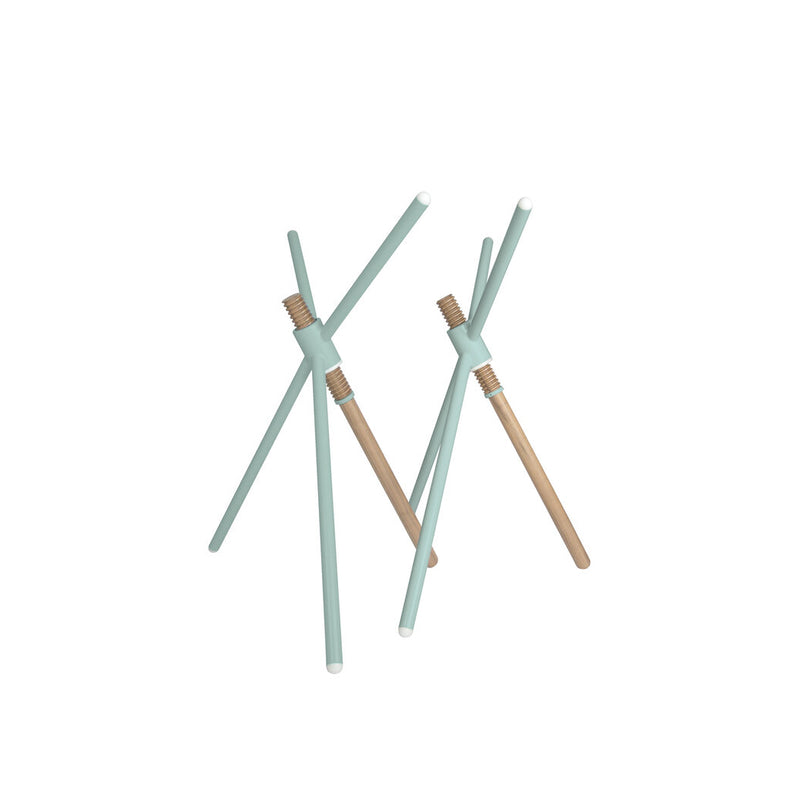 The Thread X sculpture by Coordination Berlin is a minimalist wooden piece with three intersecting light teal rods featuring white ends. Its contemporary, abstract design evokes avant-garde aesthetics, elegantly set against a plain white background.
