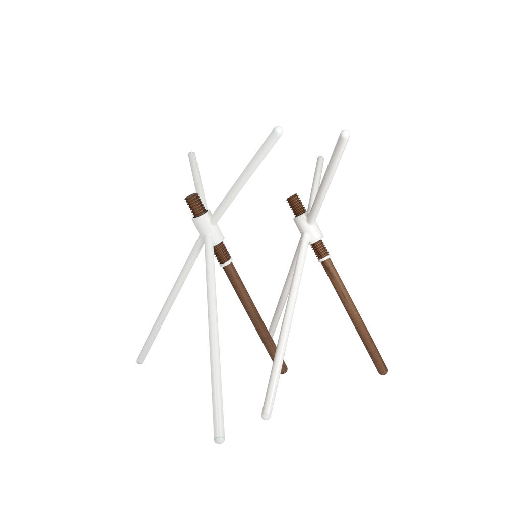 The contemporary Thread X sculpture from Coordination Berlin showcases intersecting white and brown rods resembling wooden matchsticks, evoking the elegance and versatility of height-adjustable furniture against a white backdrop.