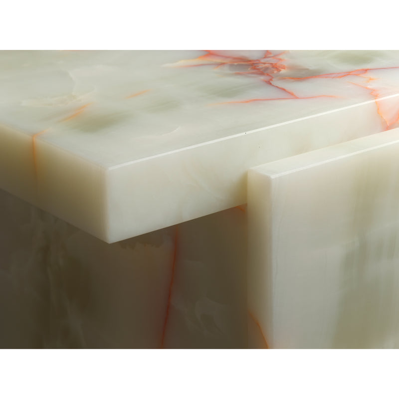 Close-up of the E15 DT02 TORE ONYX table, featuring a smooth pale green Art Deco onyx surface with subtle orange and red veining. The photo accentuates its corner and thick slab design, reminiscent of David Thulstrups sophisticated style.