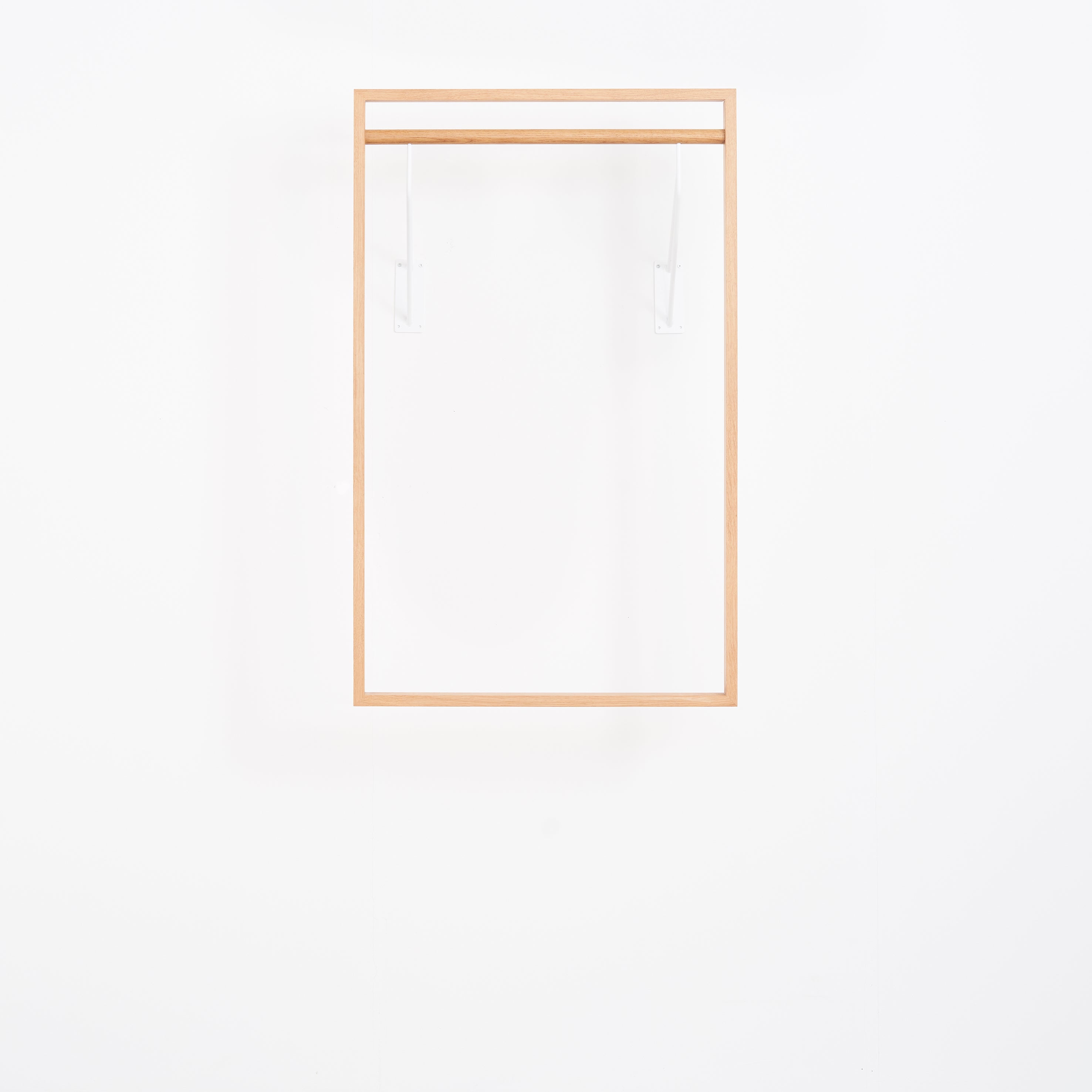 The Gardero-b by Das kleine b is a minimalist wooden square frame with two transparent brackets, designed to maximize wardrobe space on a white background. Its design is sleek and simplistic.