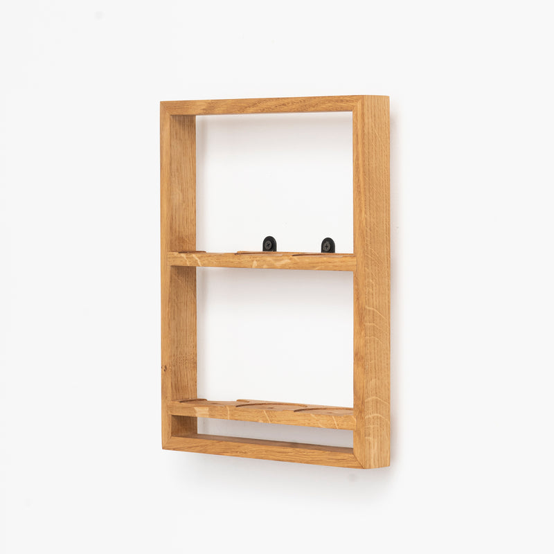 The Spice Rack Bocuse by Das kleine b is a wooden, wall-mounted shelf featuring two sections ideal for spice jars. Displayed against a plain white background, it highlights a simple, minimalist design in light-colored wood.