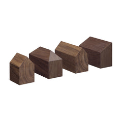 Four European oak blocks shaped like simple houses, with triangular roofs and rectangular bases, are showcased against a white background. These minimalist AC10 HAUS designs by E15 are perfect as elegant desk accessories or paperweights.
