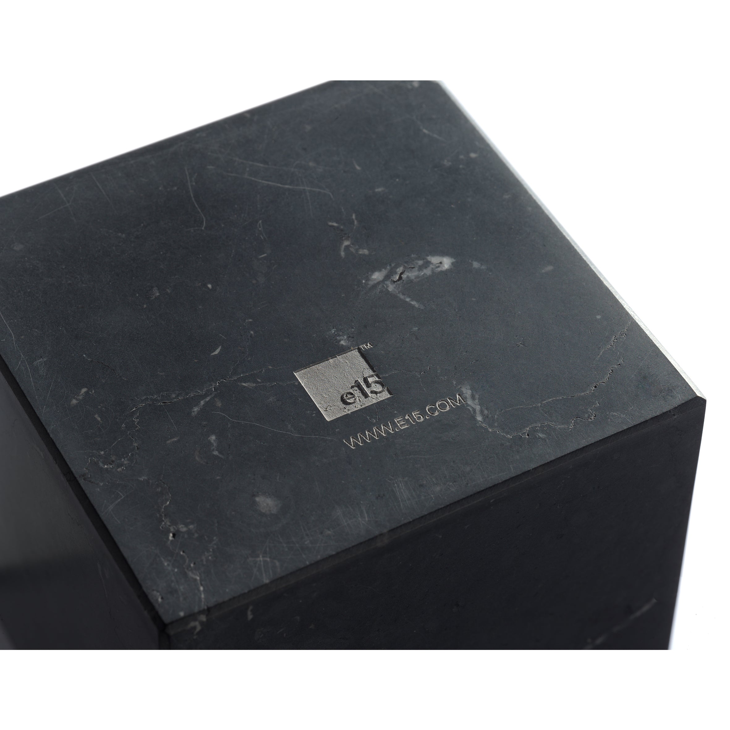 Close-up of the AC11 STOP, a sophisticated black marble bookend by E15. A small engraved metal plate shows e15 and www.e15.com. Designed by Philipp Mainzer, it features a smooth texture with subtle natural marble patterns.