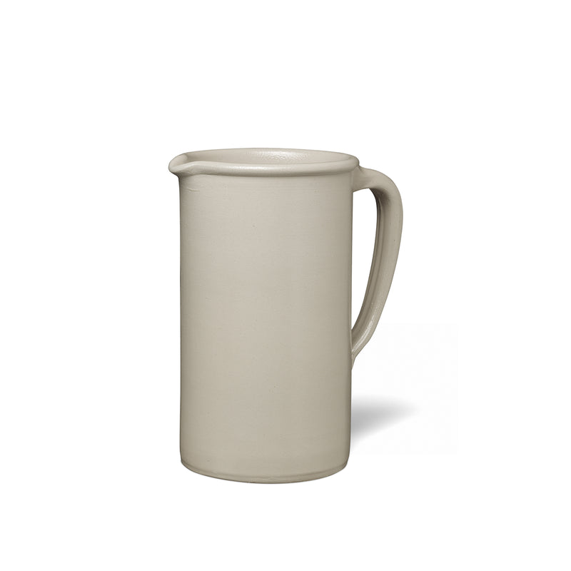 The AC19 SALINA by E15 is a tall ceramic pitcher featuring a handle and narrow spout. Its off-white, smooth matte finish reflects handmade pottery charm, elegantly standing against a plain white backdrop in modern design.