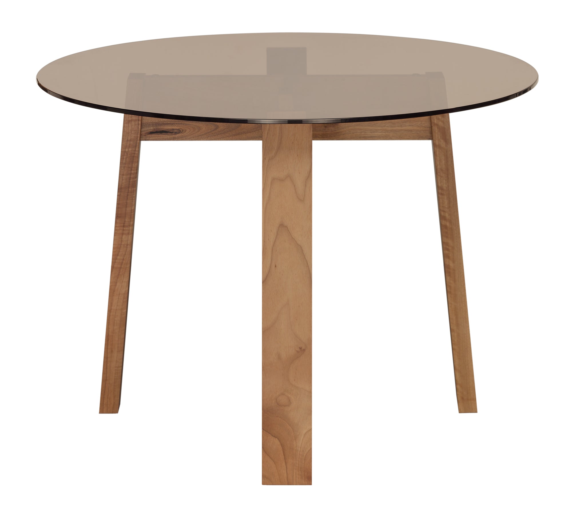 The E15 DC08 Basis Table Round features a transparent glass tabletop on a wooden tripod base, echoing classic trestle designs. The solid wood trestles meet centrally with a natural finish, offering a modern, minimalist aesthetic.