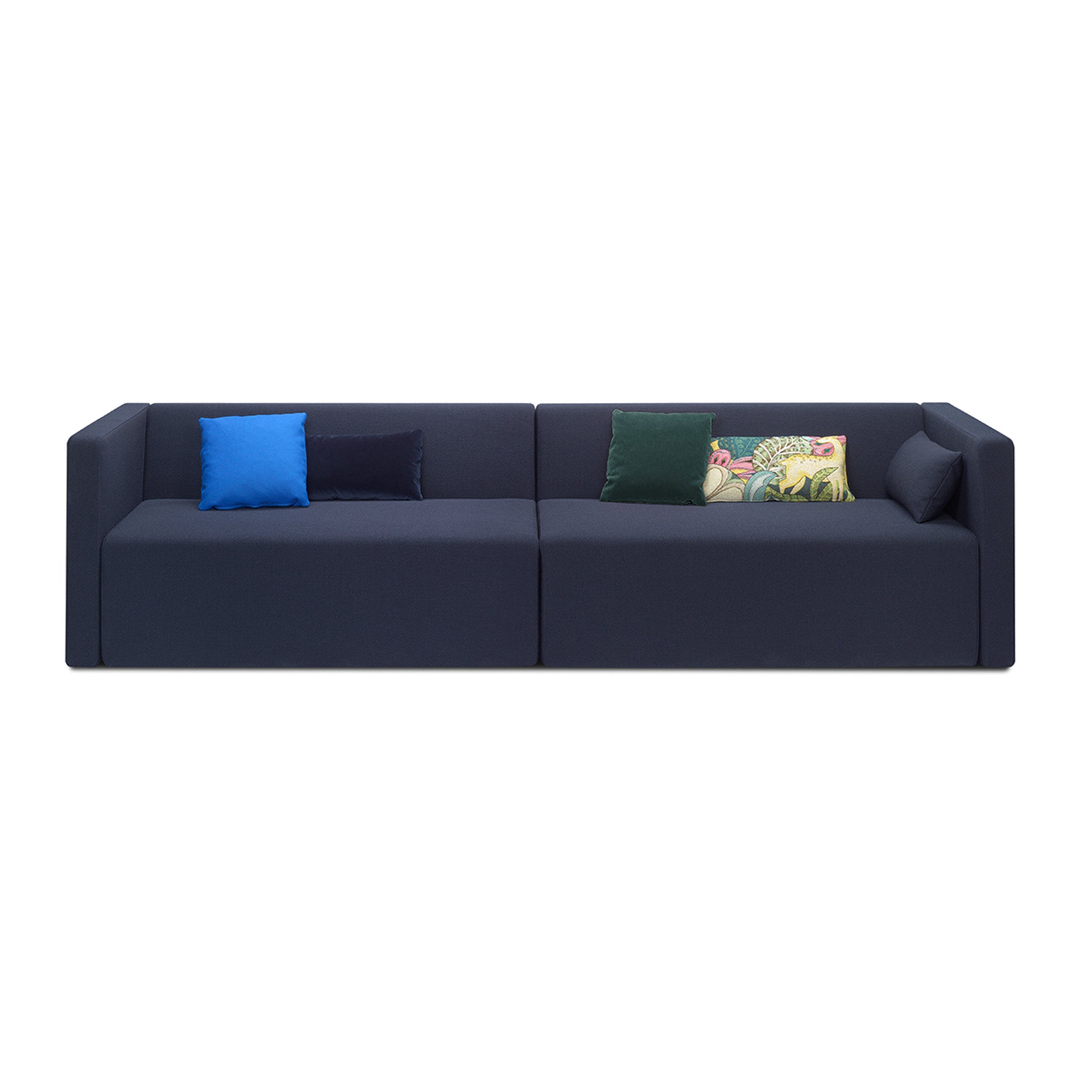 The SF06 KERMAN by E15 is a sleek, modern dark navy sofa with clean lines and no visible legs. It includes five cushions in blue, dark blue, green, gray, and a multicolored pattern, each with removable covers for easy maintenance and are evenly arranged on the seating area.