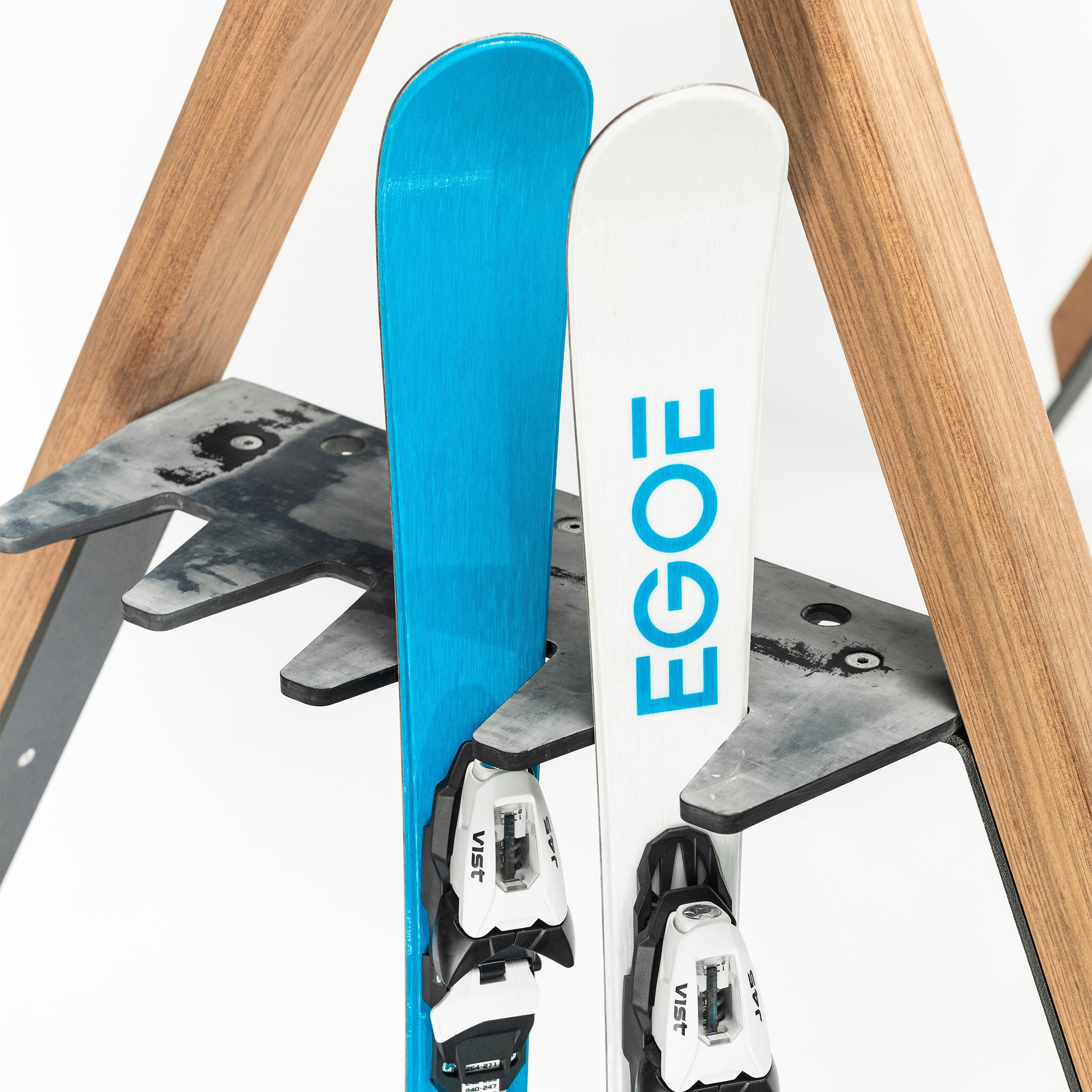 The Cabra Ski and Bike Rack by Egoe features two side-by-side skis with black and white bindings. One ski is blue, the other white with EGOE in blue, offering multifunctional use as an equipment protector to keep your gear secure and organized.