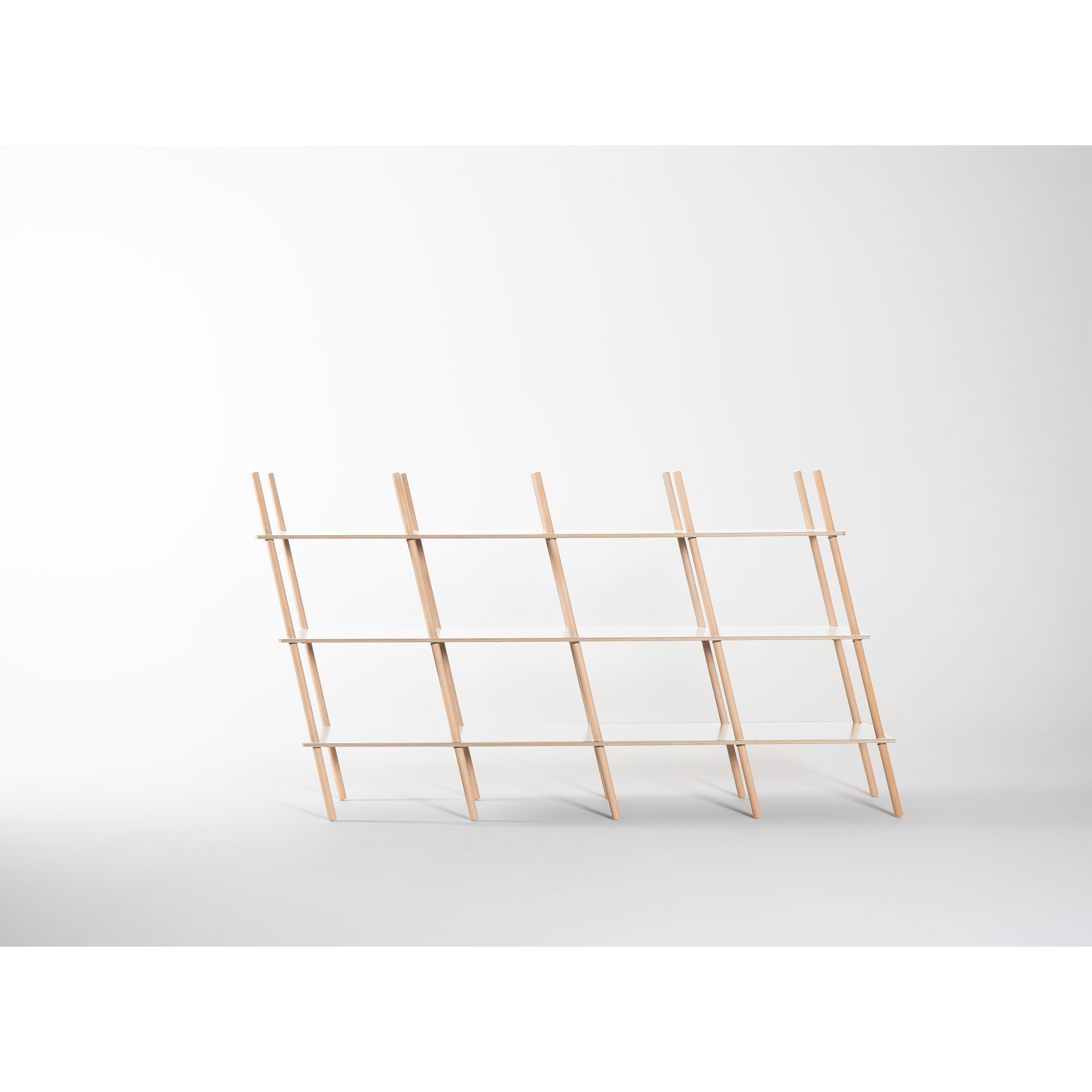 The Es Sideboard by Moormann is a minimalist shelf made of birch plywood, featuring a light wood grid with nine rectangular compartments. It leans subtly backward against a white background and showcases precise craftsmanship.