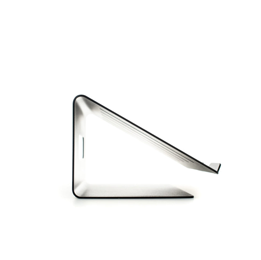 Echtstahls Laptop Stand is a minimalist, high-quality steel stand for tablets or phones with a sleek angular design on a white background. Its simple geometry and metallic finish offer a modern look, perfect for ergonomic viewing.