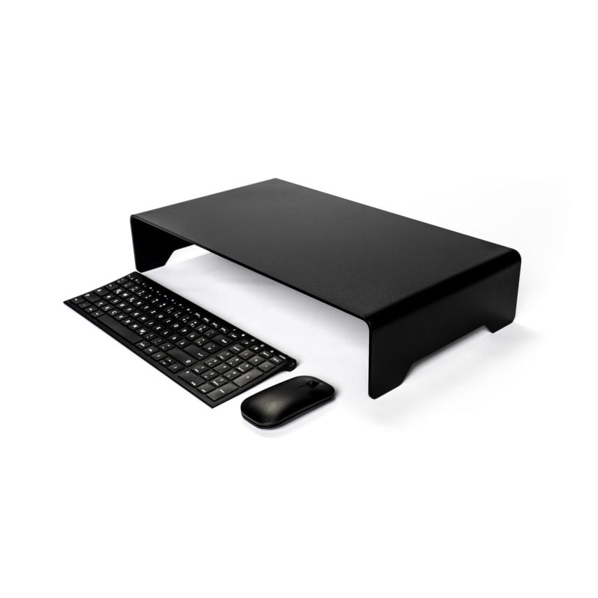 The Echtstahl Monitor Stand in powder-coated steel features a minimalist design, with a wireless keyboard and mouse neatly tucked underneath on a white surface, promoting space efficiency and ergonomic viewing.