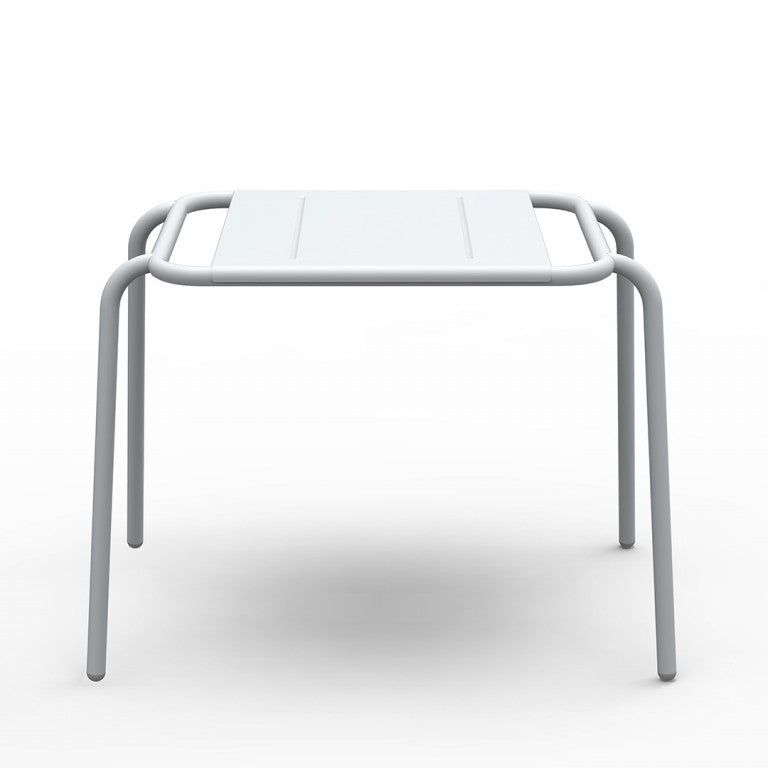 The Hama Stool by Echtstahl features a minimalist white metal design with a rectangular top and rounded corners, supported by four tubular stainless steel legs. Its sleek, modern style is perfect for both indoor and outdoor settings, with the plain backdrop highlighting its structure.