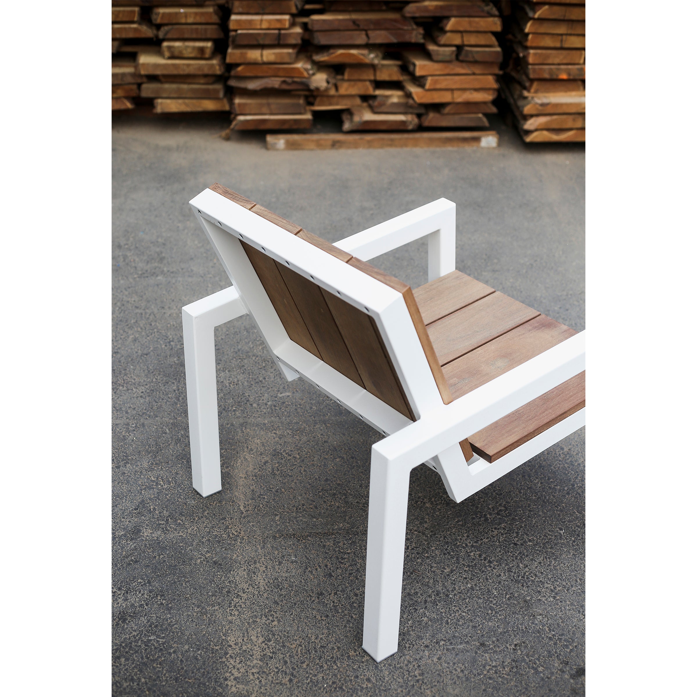 Experience the Laurede Lounge Chair by Egoe, designed with a sleek white metal frame and tropical wood slats. Ideal for sophisticated garden settings on concrete surfaces, it complements wooden plank decor beautifully.