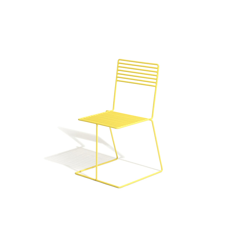 The Tina Chair by Egoe is a modern minimalist piece with a yellow metal wireframe design and powder-coated finish. Its suspended seat and backrest feature horizontal bars, elegantly resting on three legs, casting a shadow on the pristine white background.