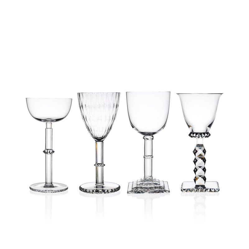 Four elegant Hoffmann Goblets by Lobmeyr, crafted from mouth-blown lead-free crystal, display unique Josef Hoffmann-inspired designs on their stems and bases. Set against a white background, each glass showcases varying shapes like round, fluted, and square bases.