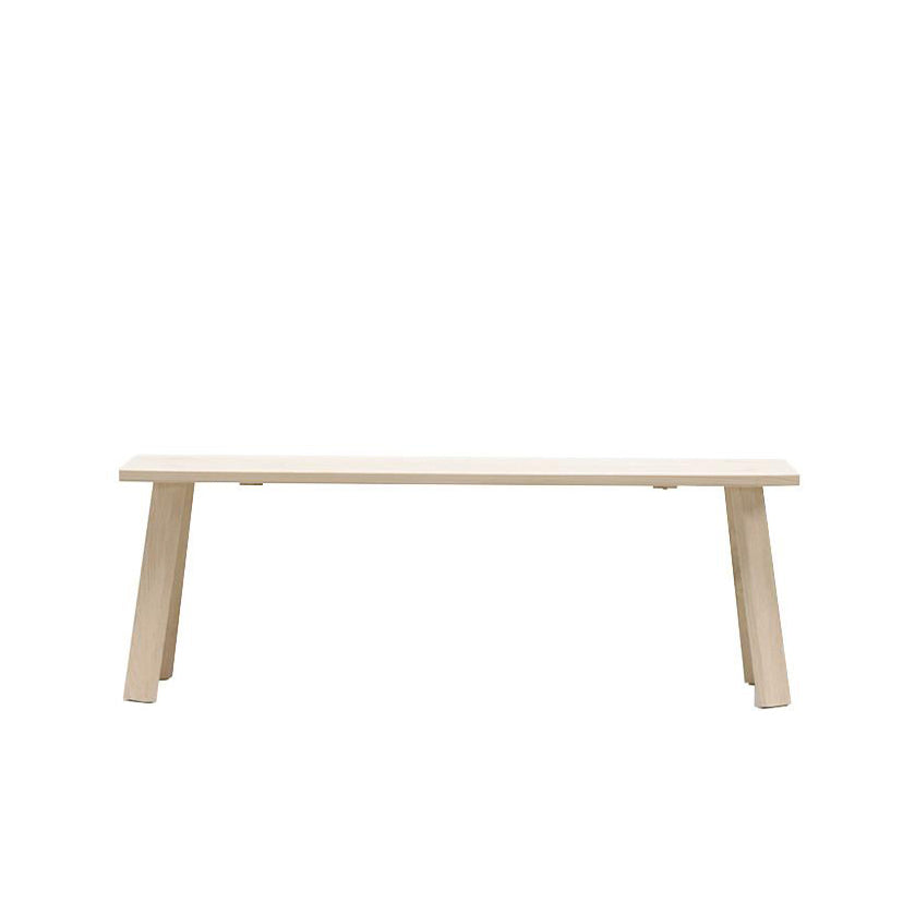 The Alpin Bench by Hussl, designed by EOOS, showcases a minimalist design with a flat seat and slanted legs in light-colored wood. This piece reflects Hussls Alpine furniture style and is displayed against a plain white background.