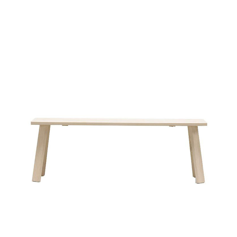 The Alpin Bench by Hussl, designed by EOOS, showcases a minimalist design with a flat seat and slanted legs in light-colored wood. This piece reflects Hussls Alpine furniture style and is displayed against a plain white background.