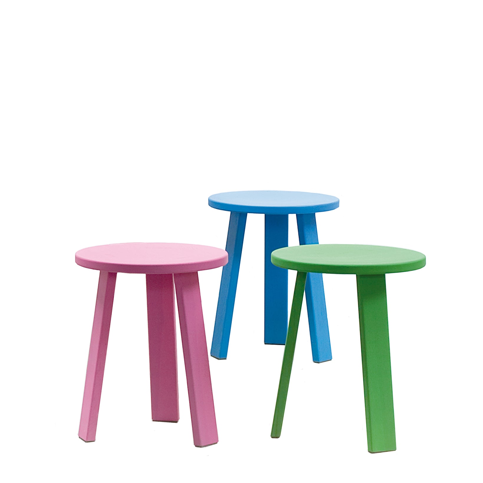 Three Hussl Alpin Tripod Stools, echoing Alpine design, rest on a white background. Each three-legged stool comes in pastel pink, blue, or green and is arranged at different angles to capture Hussl’s creative essence.