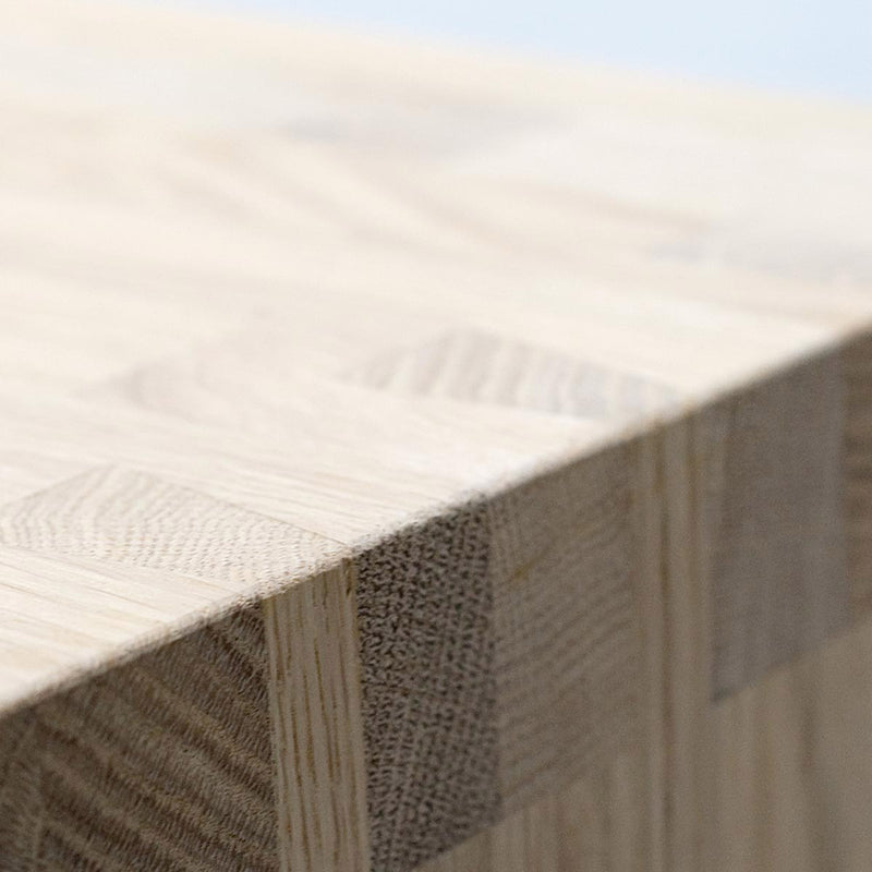 Close-up of the Hussl benchs wooden tabletop with smooth, light-colored grain. The edge showcases a visible dovetail joint, emphasizing the natural textures and craftsmanship typical of Hussl furniture.