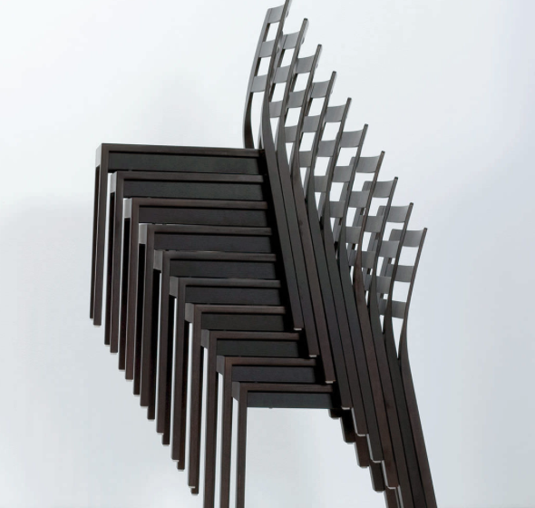 A stack of ST10 - Upholstered chairs from Hussl, featuring a sleek minimalist design, is neatly arranged against a plain background, highlighting the distinctive overlap of their backs and legs.