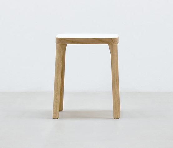 The Hussl ST6N-0 Barstool features a minimalist square white seat and four light wood legs, evoking Austrian coffee house style, set against a plain light gray background.