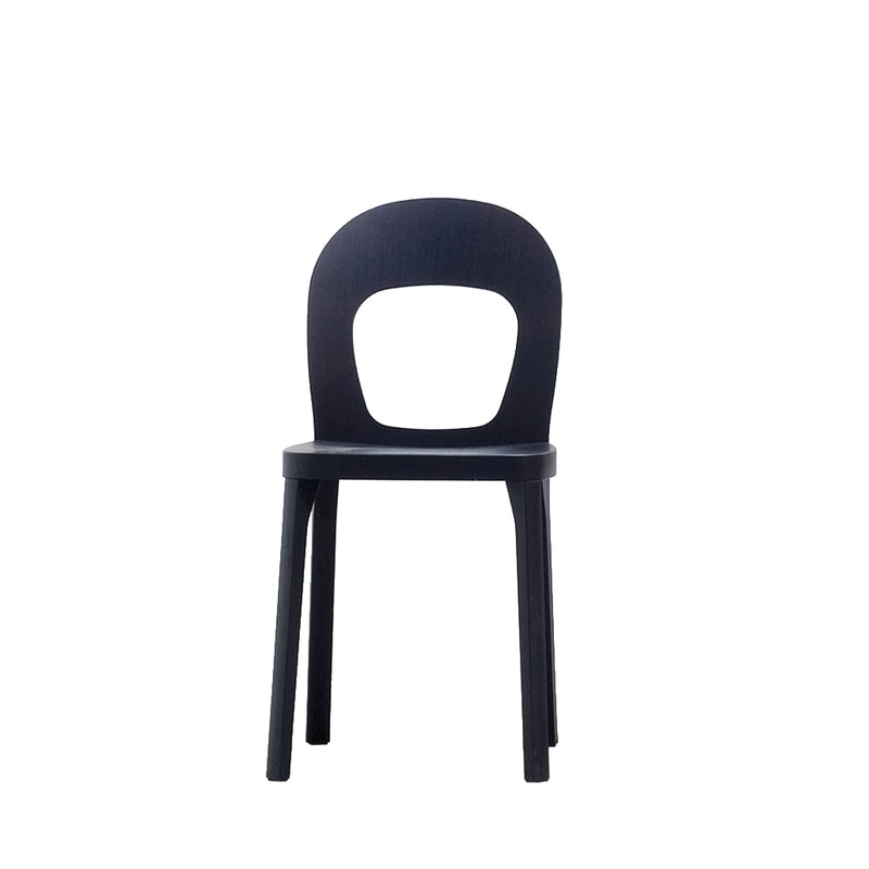Discover the Hussl ST6N-1: a modern, minimalist black chair inspired by Austrian coffee house design. It features an open oval cutout on its rounded backrest and four straight legs supporting a smooth seat, all highlighted against a plain white background.