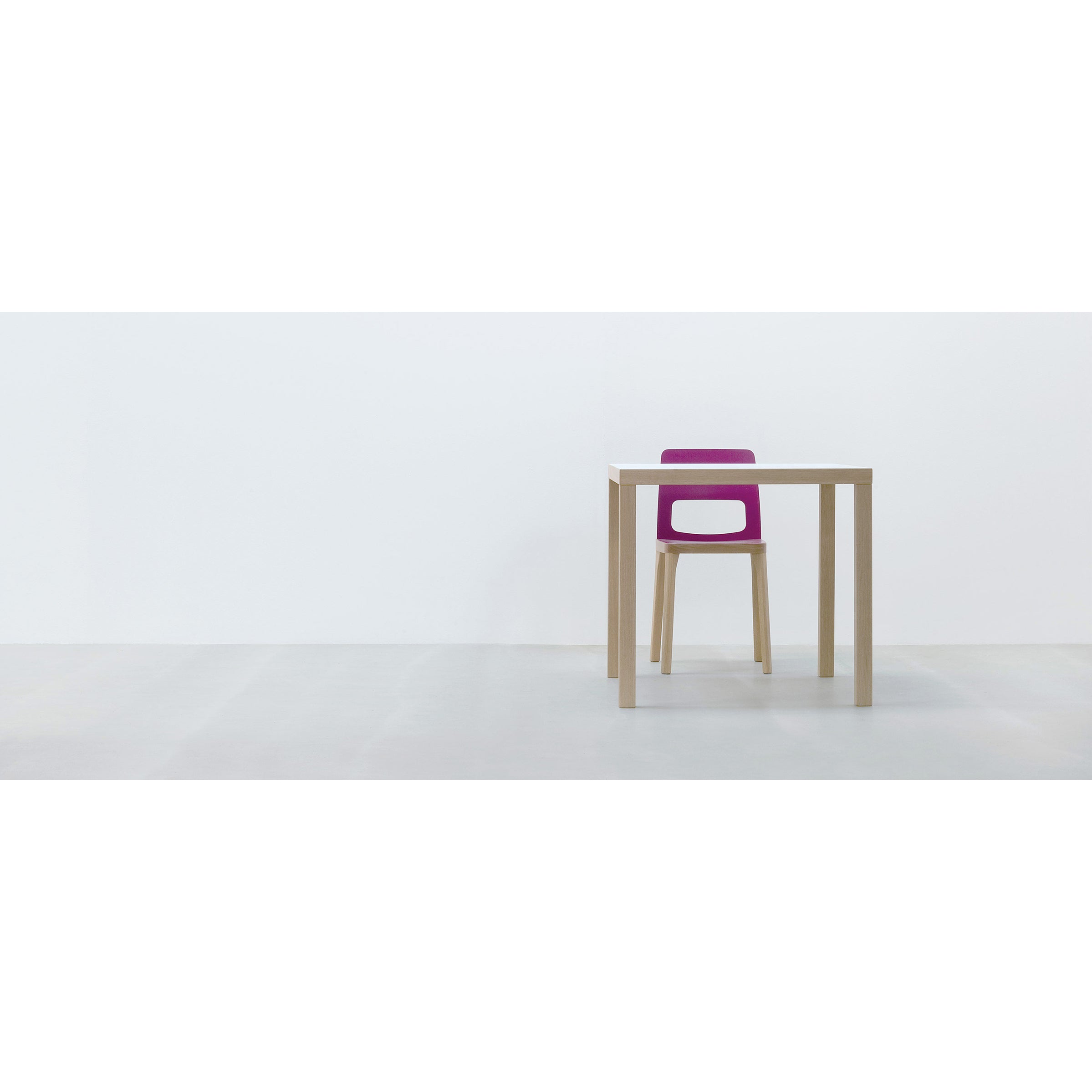 A minimalist setup with the Hussl TC4 table and a chair with a purple backrest, set against a white wall and durable gray floor—ideal for dynamic business settings.