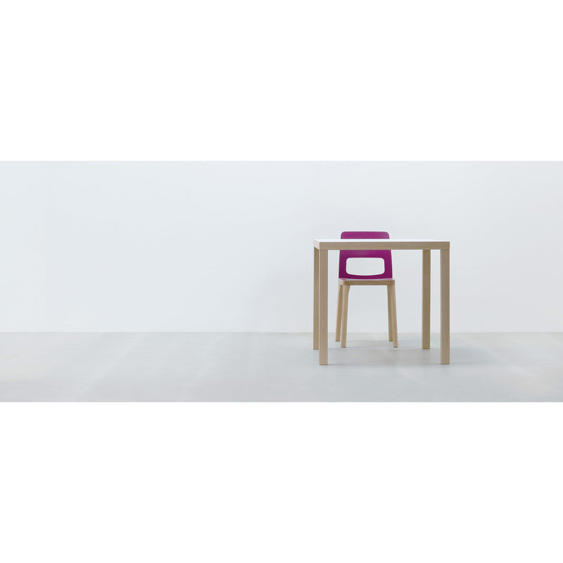A minimalist setup with the Hussl TC4 table and a chair with a purple backrest, set against a white wall and durable gray floor—ideal for dynamic business settings.