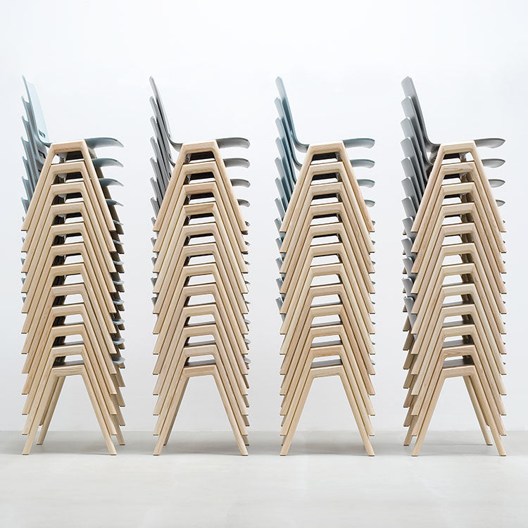 Four stacks of stackable Forum 2S chairs, each with six seats, are arranged in a row against a plain white background. Made by Hussl, these chairs feature solid wood frames and pale blue upholstered seats. The side view highlights their uniformity and design.