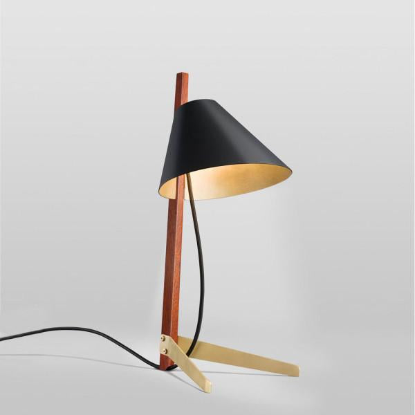 The Kalmar Billy Table Ilse Crawford Edition is a modern table lamp with a minimalist design, featuring a black conical shade and rosewood stem. Its beige angular legs with satin-brass feet and visible power cord elegantly connect to the base.
