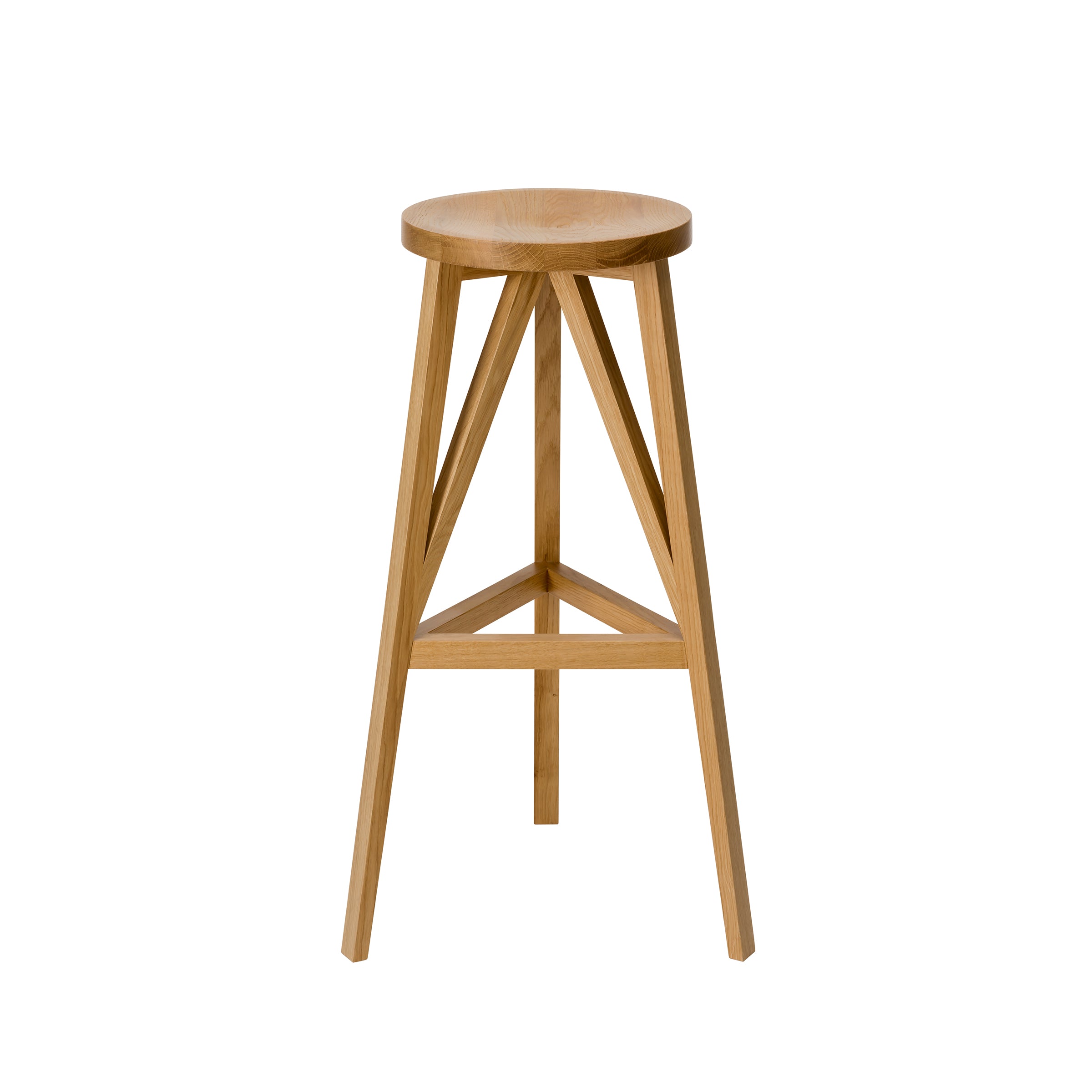 The JL4 Faber Barstool by Loehr features a wooden round seat with triangular support beams, creating a unique silhouette. Its three angled legs form a minimalist, modern design crafted from solid oak with a natural finish that highlights the woods texture and grain.