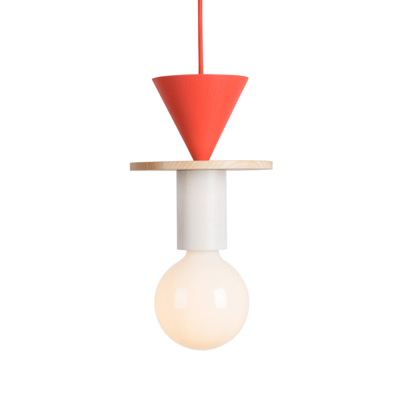 The Junit Record by Schneid is a modern modular pendant lamp, uniquely designed with a red conical top, ash wood disc centerpiece, and white cylindrical section above a round bulb. It hangs gracefully from a red cord, providing ambient light.